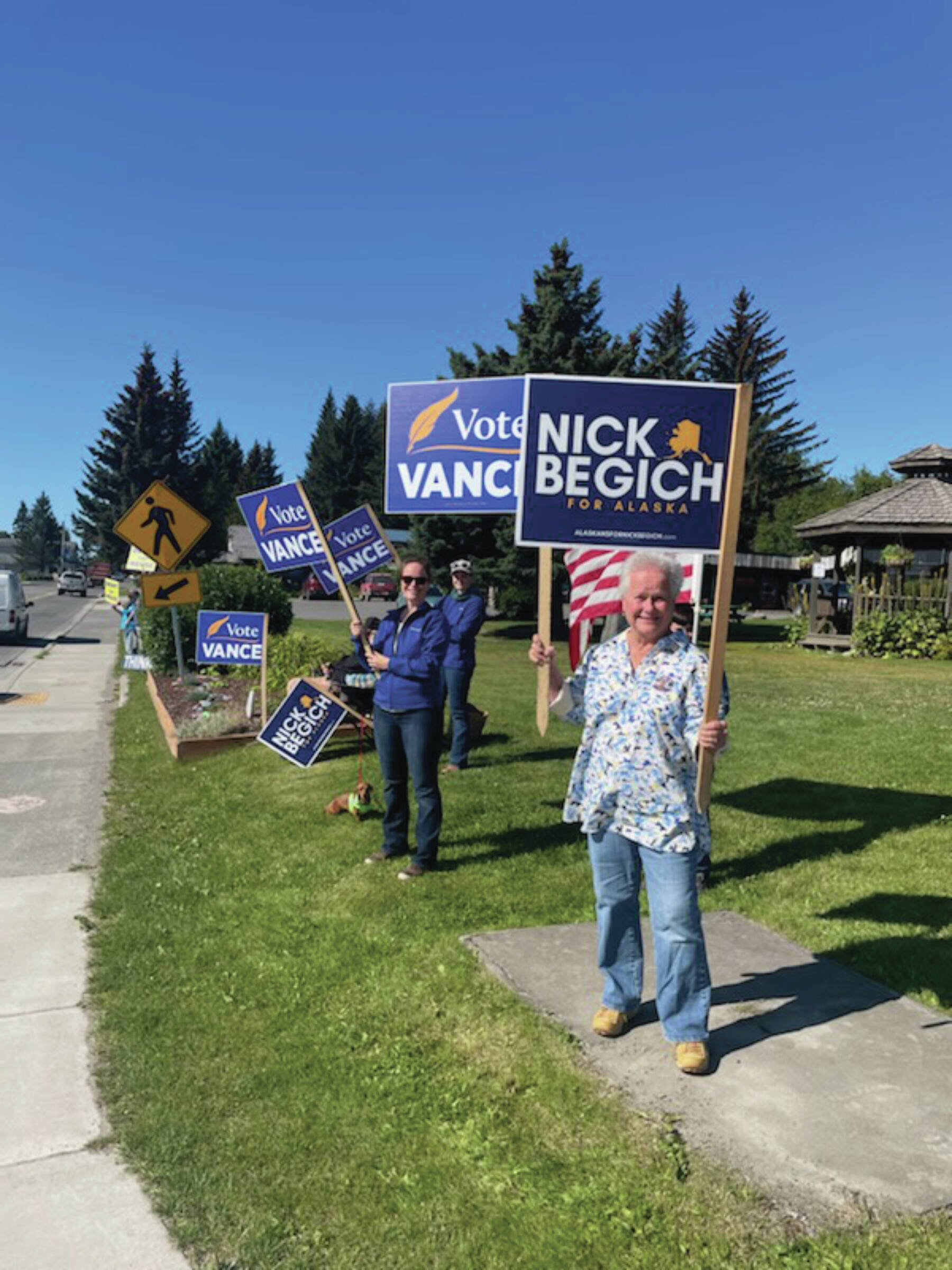 Homer residents hold political signs in support of Alaska House District 6 candidates at WKFL park on Aug. 20, 2024, in Homer, Alaska. (Emilie Springer/ Homer News)