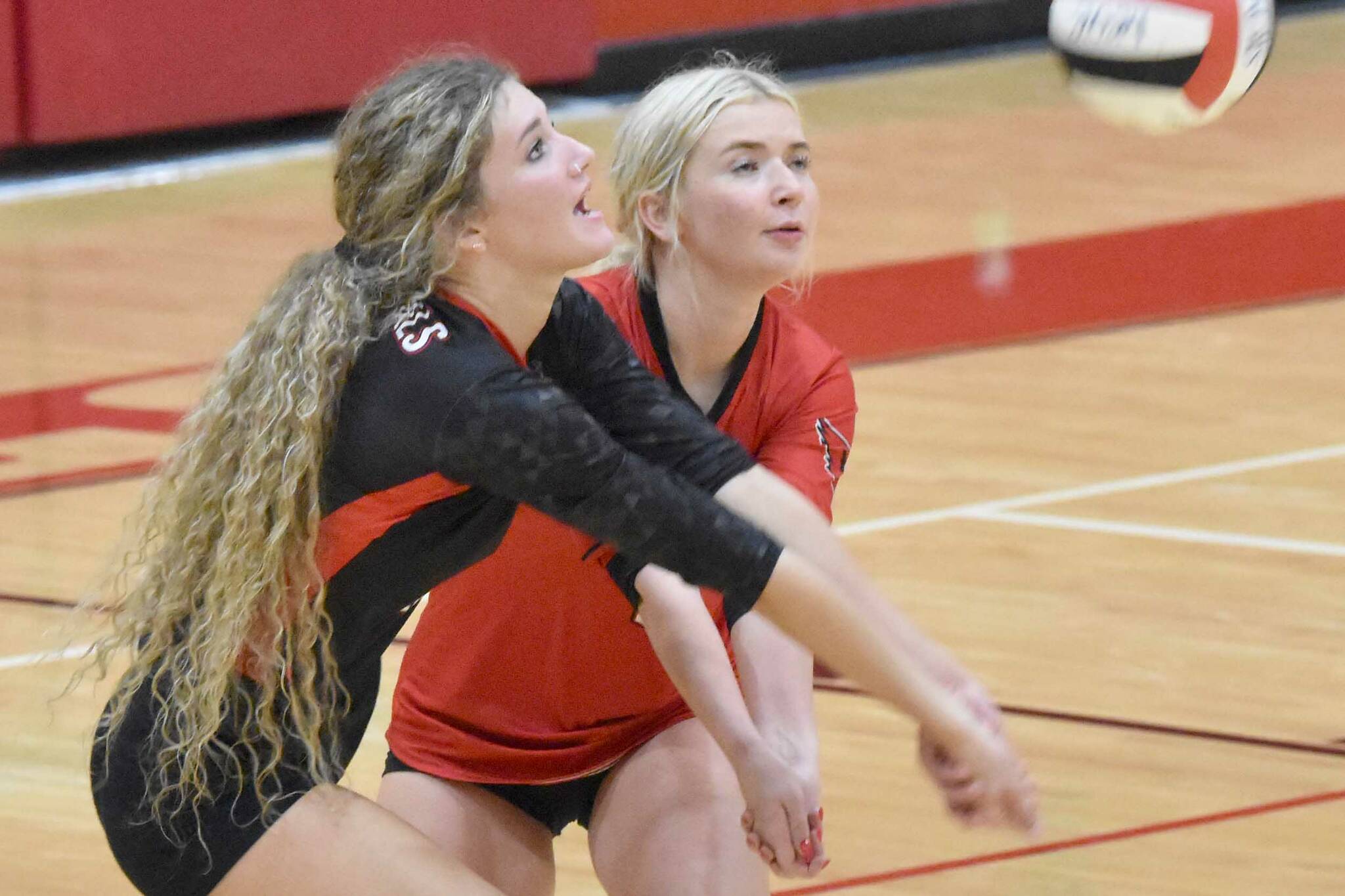 Sophie Tapley and Brynnen Hansen dig up a ball at Kenai Central High School in Kenai, Alaska, on Thursday, Aug. 29, 2024. (Photo by Jeff Helminiak/Peninsula Clarion)