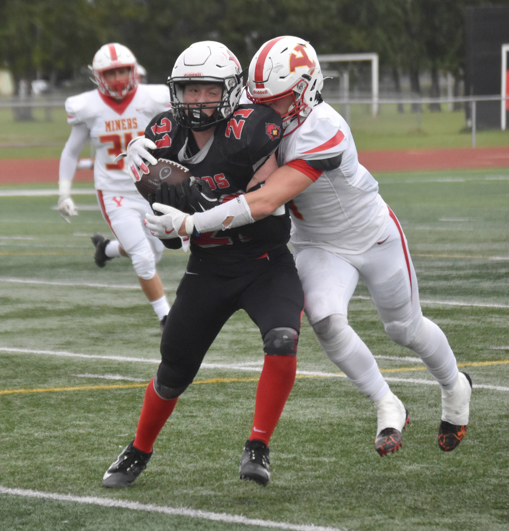 Kenai Central's Hollan Chadwick catches a pass in front of Ryan Warfield of Yreka (California) on Friday, Aug. 30, 2024, at Ed Hollier Field at Kenai Central HIgh School in Kenai, Alaska. (Photo by Jeff Helminiak/Peninsula Clarion)