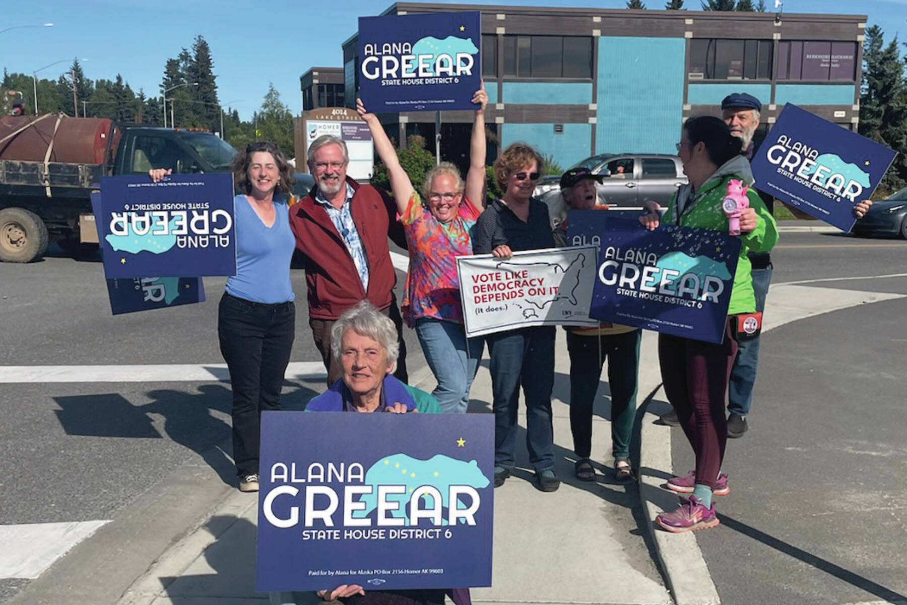 Alaska House District 6 candidate Alana Greear (back, center) poses with supporters at the corner of Pioneer Avenue and Lake Street in Homer during the primary election on Aug. 20, 2024. (Emilie Springer/Homer New)