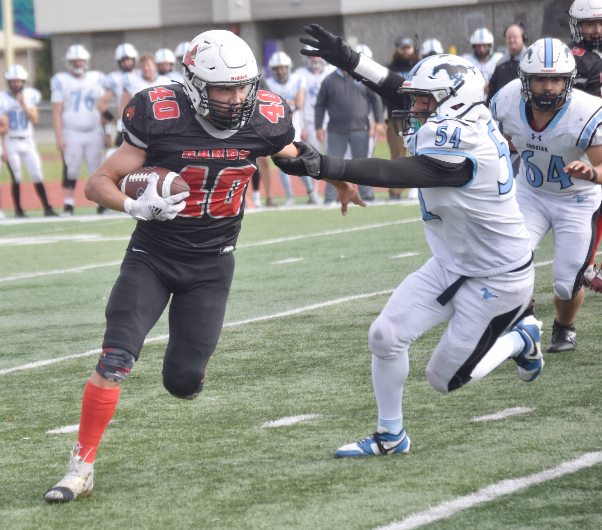 Kenai Central’s Bobby Hayes runs against Chugiak’s Elijah Ortega on Saturday, Sept. 7, 2024, at Ed Hollier Field at Kenai Central High School in Kenai, Alaska. (Photo by Jeff Helminiak/Peninsula Clarion)