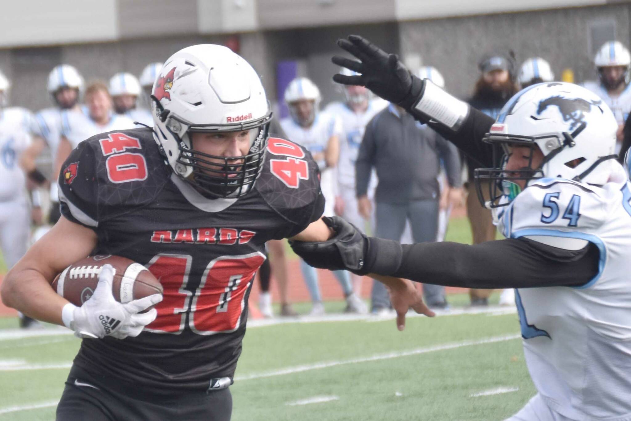 Kenai Central's Bobby Hayes runs against Chugiak's Elijah Ortega on Saturday, Sept. 7, 2024, at Ed Hollier Field at Kenai Central High School in Kenai, Alaska. (Photo by Jeff Helminiak/Peninsula Clarion)