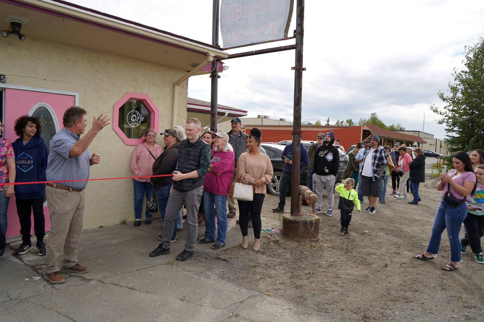 Kenai Mayor Brian Gabriel waves to a line of people during a ribbon-cutting event for The Glaze in Kenai, Alaska, on Wednesday, Sept. 4, 2024. (Jake Dye/Peninsula Clarion)