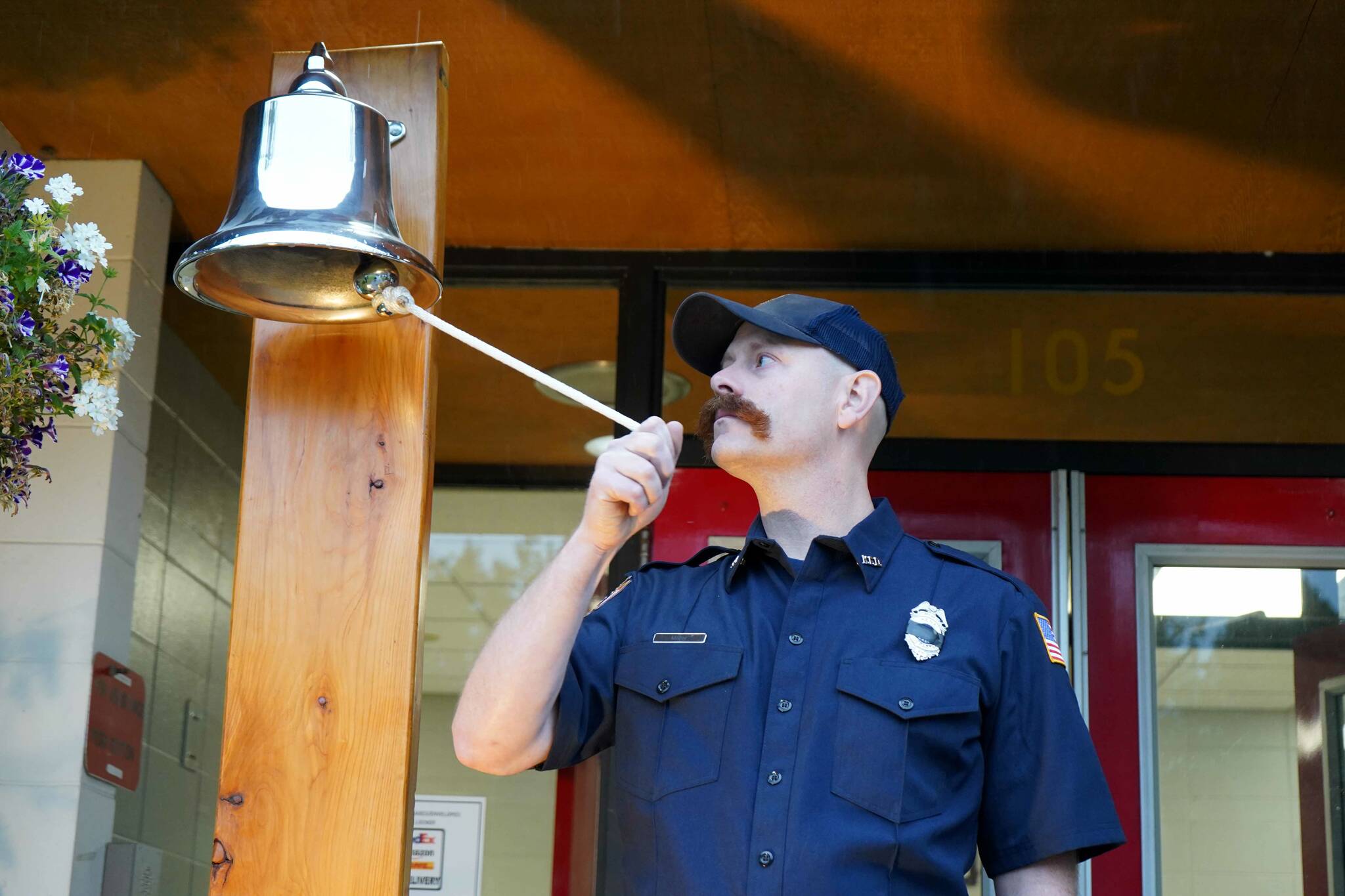 Mitch Miller, of the Kenai Fire Department, rings a bell in commemoration of the emergency services personnel who lost their lives in the Sept. 11, 2001, attacks during a commemoration ceremony at Kenai Fire Department in Kenai, Alaska, on Wednesday, Sept. 11, 2024. (Jake Dye/Peninsula Clarion)