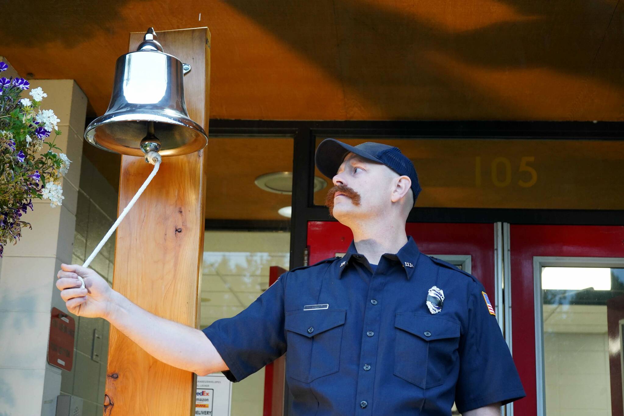 Mitch Miller, of the Kenai Fire Department, rings a bell in commemoration of the emergency services personnel who lost their lives in the Sept. 11, 2001, attacks during a commemoration ceremony at Kenai Fire Department in Kenai, Alaska, on Wednesday, Sept. 11, 2024. (Jake Dye/Peninsula Clarion)