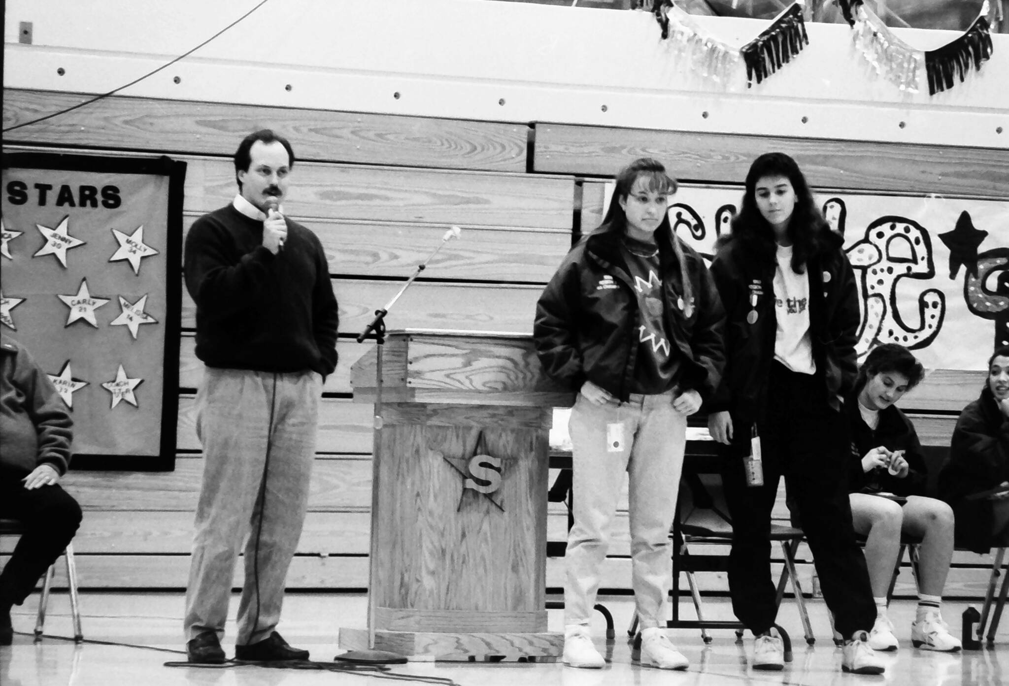 Molly Tuter, far right, is pictured as Coach Dan Gensel, far left, prepares to get his ear pierced to celebrate Soldotna High School’s first team-sport state championship on Friday, Feb. 12, 1993 in Soldotna. Gensel, who led the Soldotna High School girls basketball team to victory, had promised his team earlier in the season that he would get his ear pierced if they won the state title. (Rusty Swan/Peninsula Clarion)