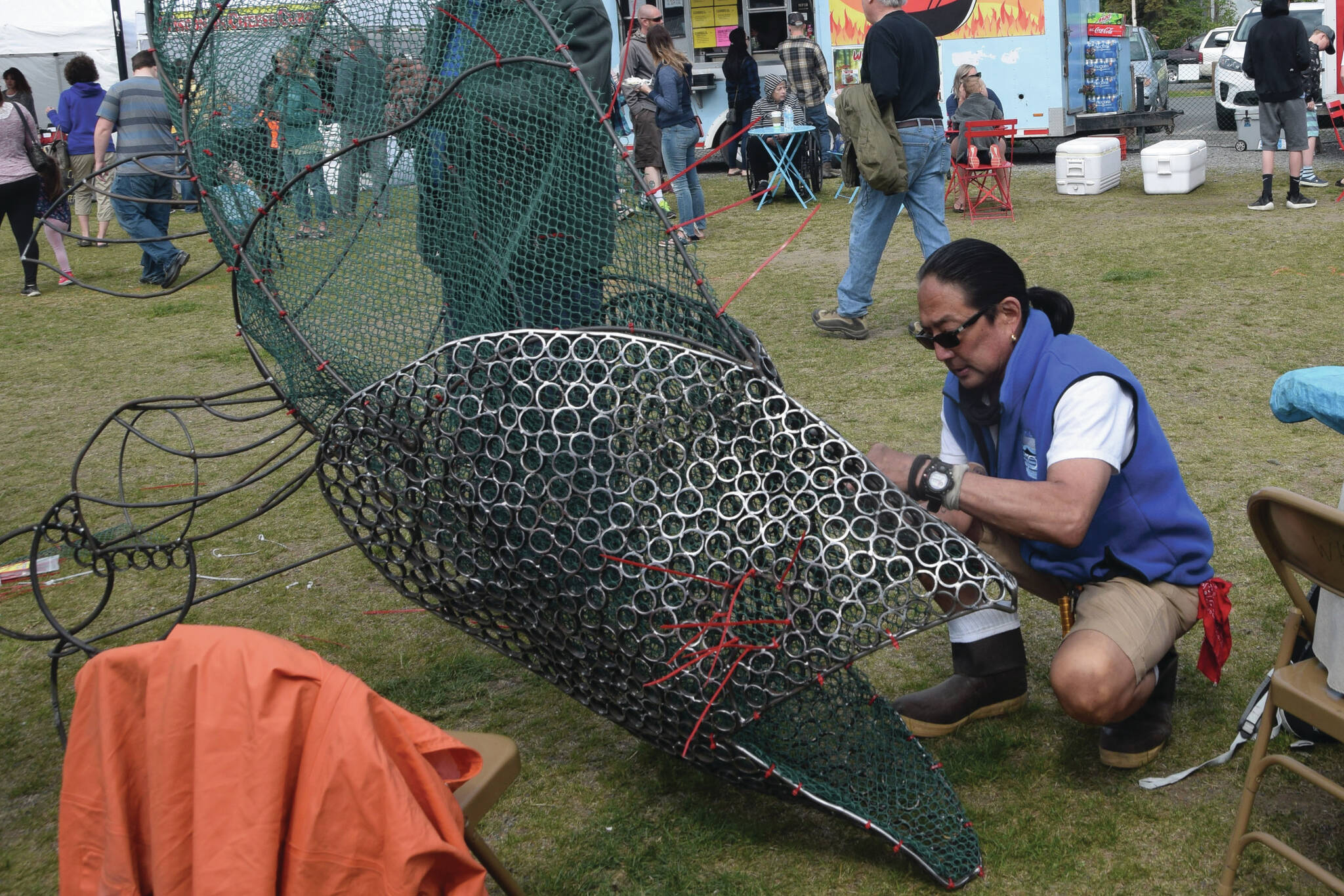 Photo by Brian Mazurek/Peninsula Clarion
Cam Choy, Associate Professor of Art at Kenai Peninsula College, works on a salmon sculpture in collaboration with the Kenai Watershed Forum during the Kenai River Festival at Soldotna Creek Park in Soldotna, Alaska on June 8, 2019.