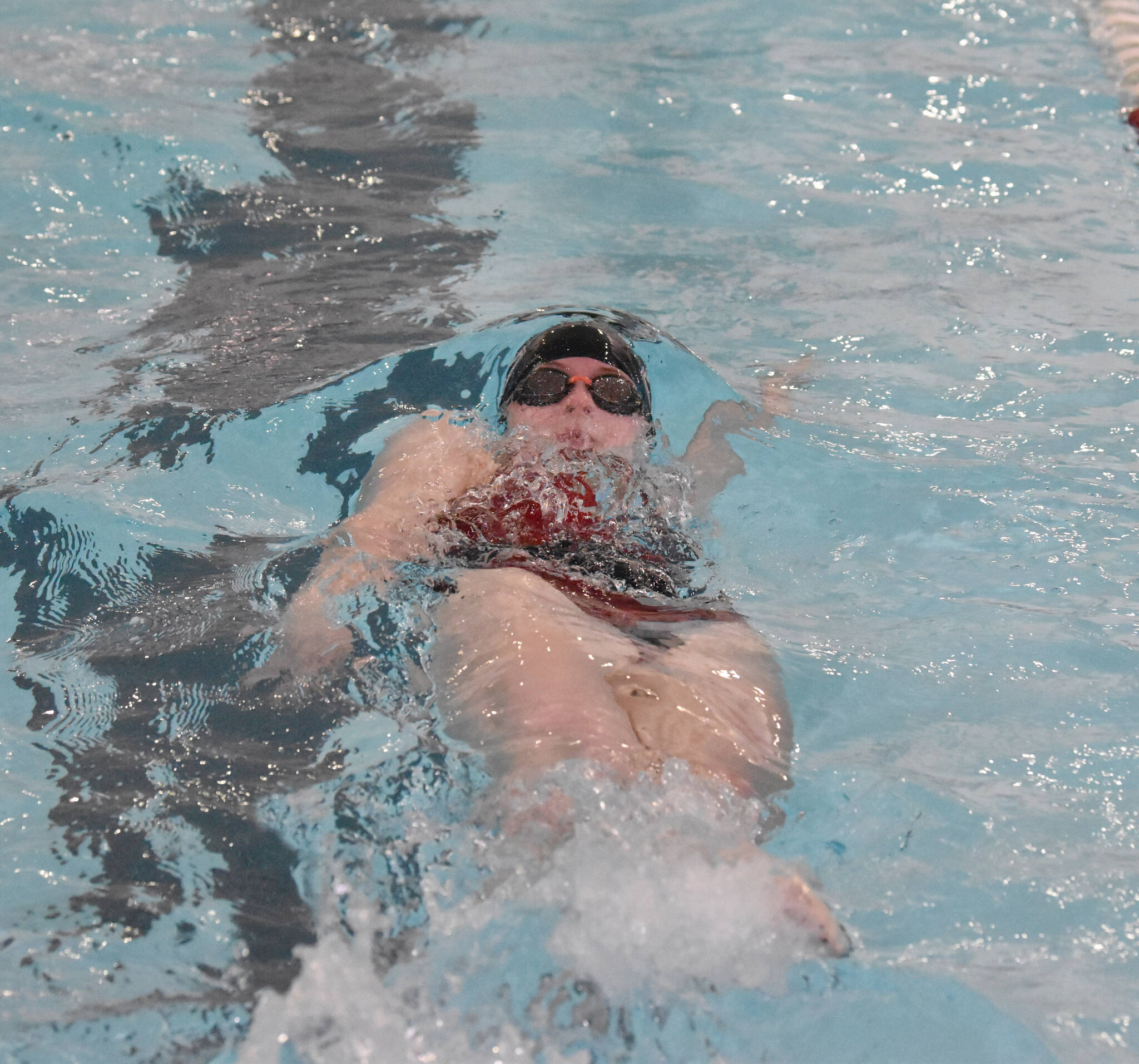 Kenai Central’s Lucy Anderson competes in the 100-yard backstroke at the Kenai Invitational on Saturday, Sept. 21, 2024, at Kenai Central High School in Kenai, Alaska. (Photo by Jeff Helminiak/Peninsula Clarion)