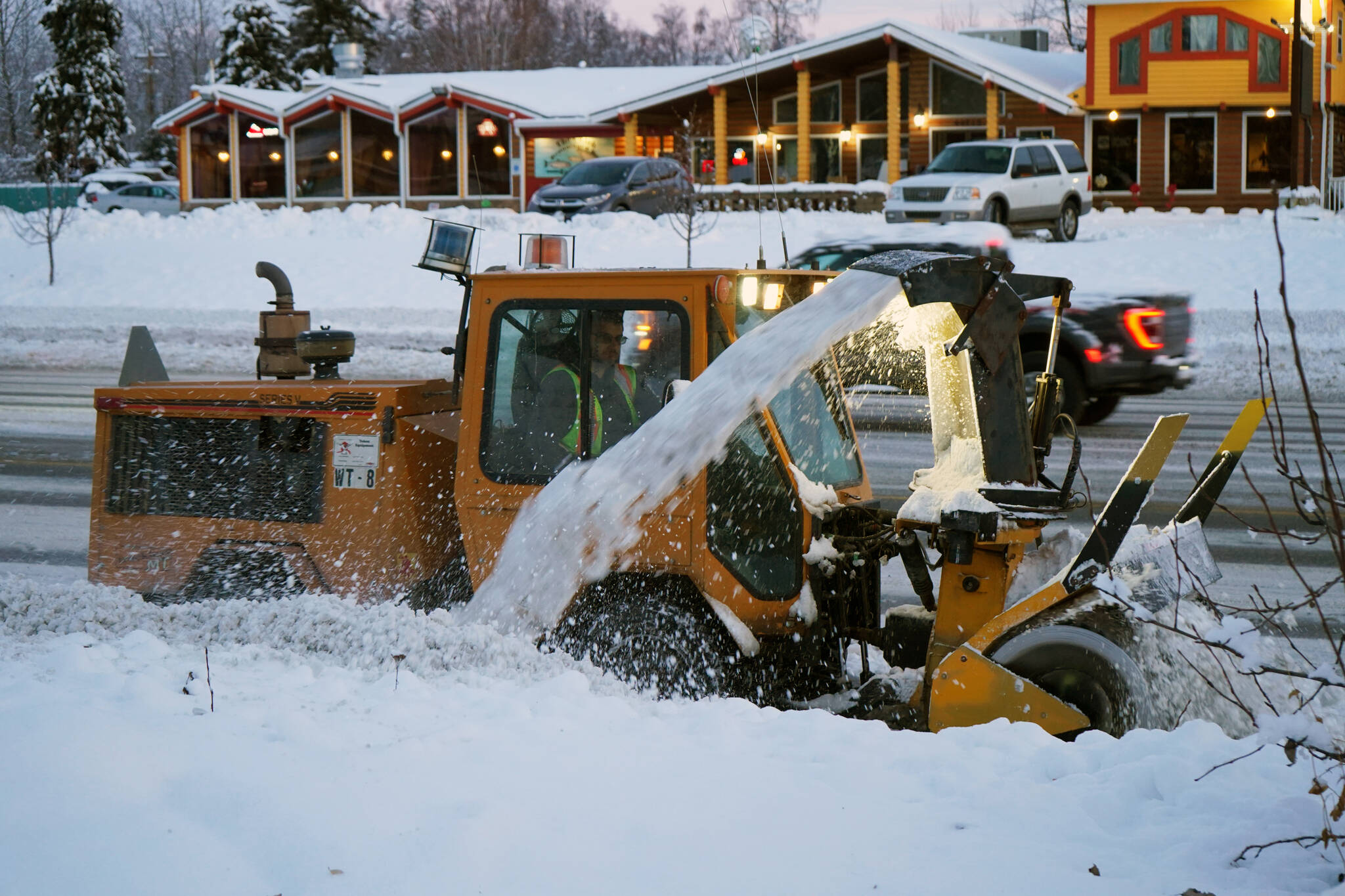 Snow is cleared from a sidewalk along the Sterling Highway in Soldotna, Alaska, on Thursday, Nov. 9, 2023. This tractor is similar to the new Trackless MT 7 and snowblower attachment being purchased by the city for this coming winter. (Jake Dye/Peninsula Clarion file)