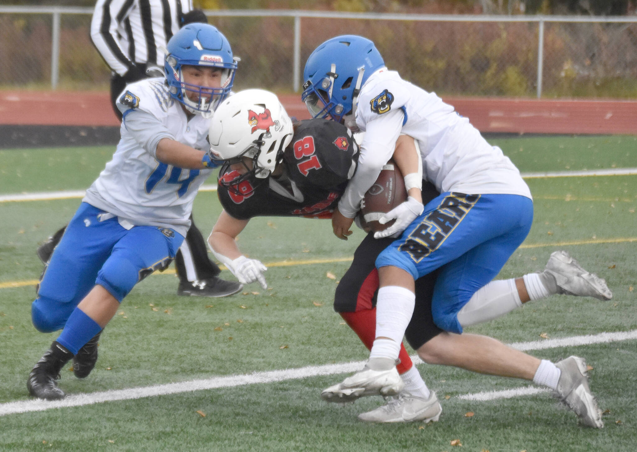 Kenai Central’s Aasen Campanella plows through Kodiak’s Gavin Peterson and Victoriano Sorio for a touchdown Saturday, Sept. 28, 2024, at Ed Hollier Field at Kenai Central High School in Kenai, Alaska. (Photo by Jeff Helminiak/Peninsula Clarion)