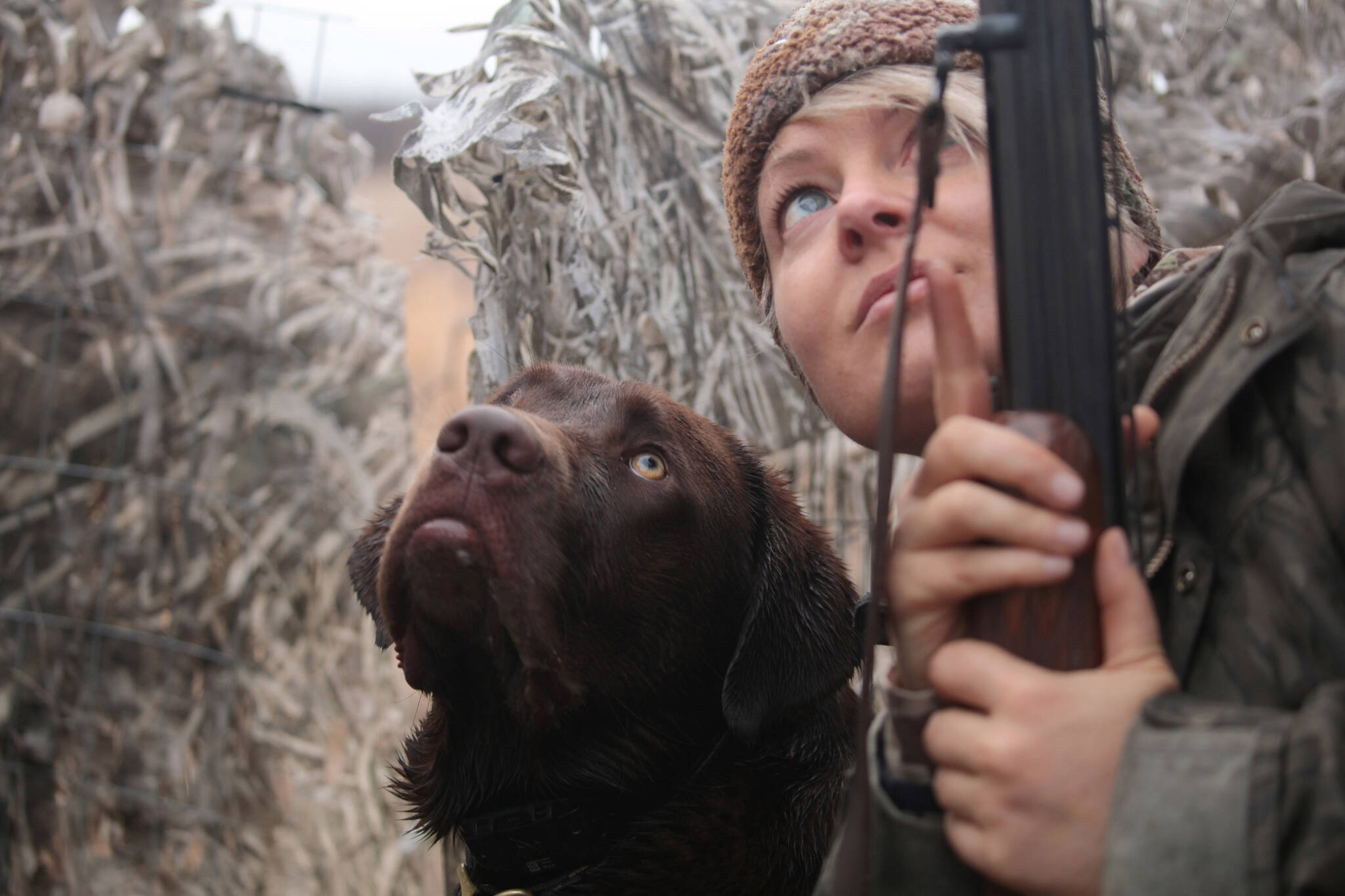 Rigby and Christine Cunningham patiently waiting in a duck blind, both watching a flock of teal high overhead. (Photo by Steve Meyer)