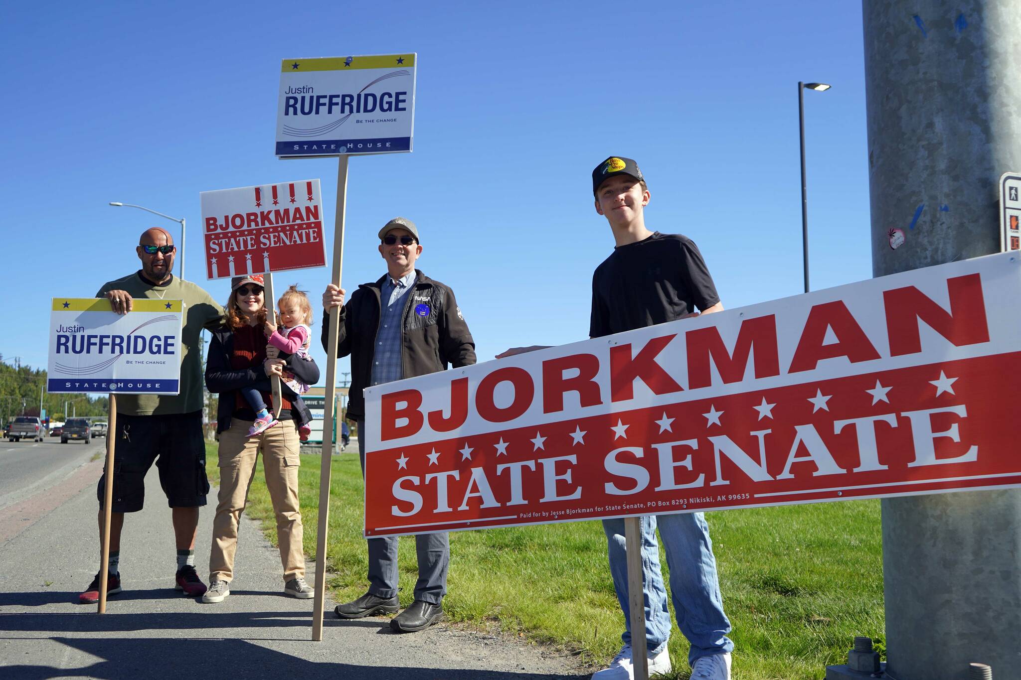 Supporters of Rep. Justin Ruffridge, R-Soldotna, and Sen. Jesse Bjorkman, R-Nikiski, wave signs on the side of the Sterling Highway in Soldotna, Alaska, during the Alaska Primary Election Day on Tuesday, Aug. 20, 2024. (Jake Dye/Peninsula Clarion)