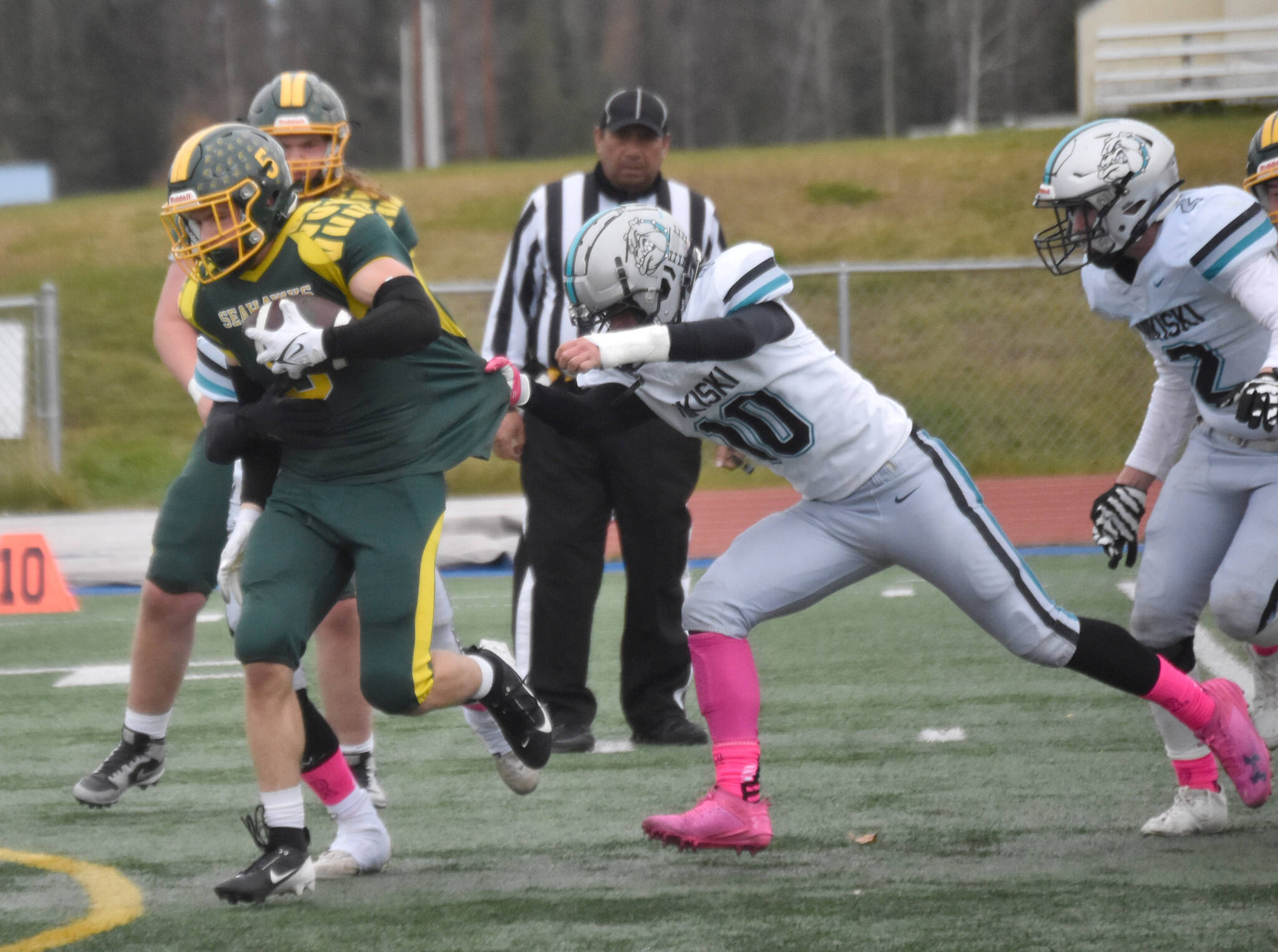 Seward’s Ronan Bickling is dragged down by Nikiski’s James Hemphill on Friday, Oct. 11, 2024, at Justin Maile Field in Soldotna, Alaska. (Photo by Jeff Helminiak/Peninsula Clarion)