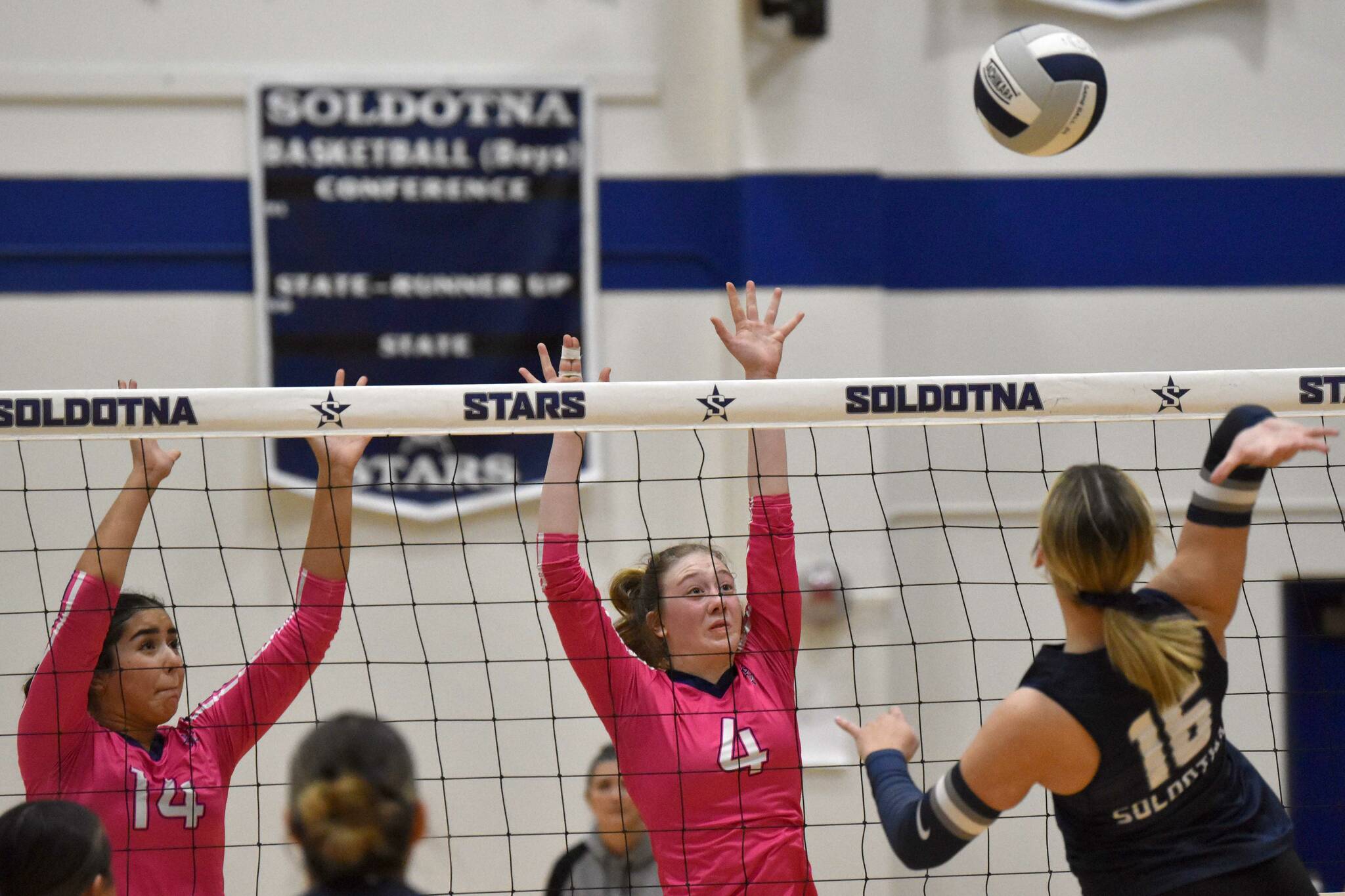 Homer's Maya Diaz and Reilly Sue Baker block against Soldotna's Abygale Schaeffer on Tuesday, Oct. 15, 2024, at Soldotna High School in Soldotna, Alaska. (Photo by Jeff Helminiak/Peninsula Clarion)