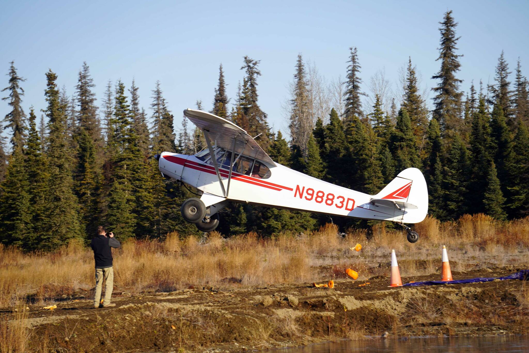 A pumpkin tumbles from a plane above the Kenai Airpark near Kenai, Alaska, during the Sixth Annual Kenai Aviation Pumpkin Drop on Saturday, Oct. 19, 2024. (Jake Dye/Peninsula Clarion)