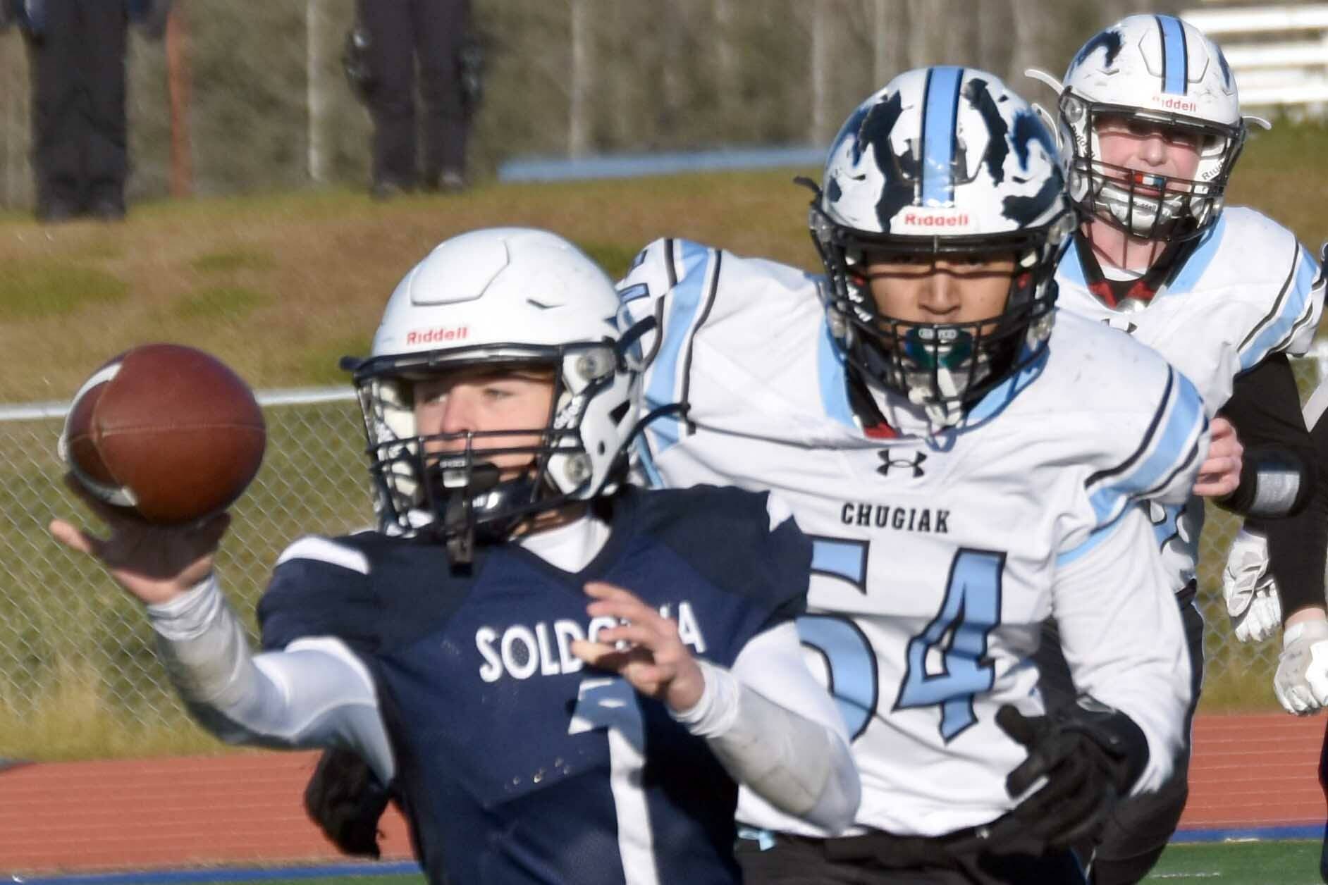 Soldotna's Owen Buckbee pitches the ball in front of Chugiak's Elijah Ortega in the Division II semifinal Saturday, Oct. 19, 2024, at Justin Maile Field at Soldotna High School in Soldotna, Alaska. (Photo by Jeff Helminiak/Peninsula Clarion)