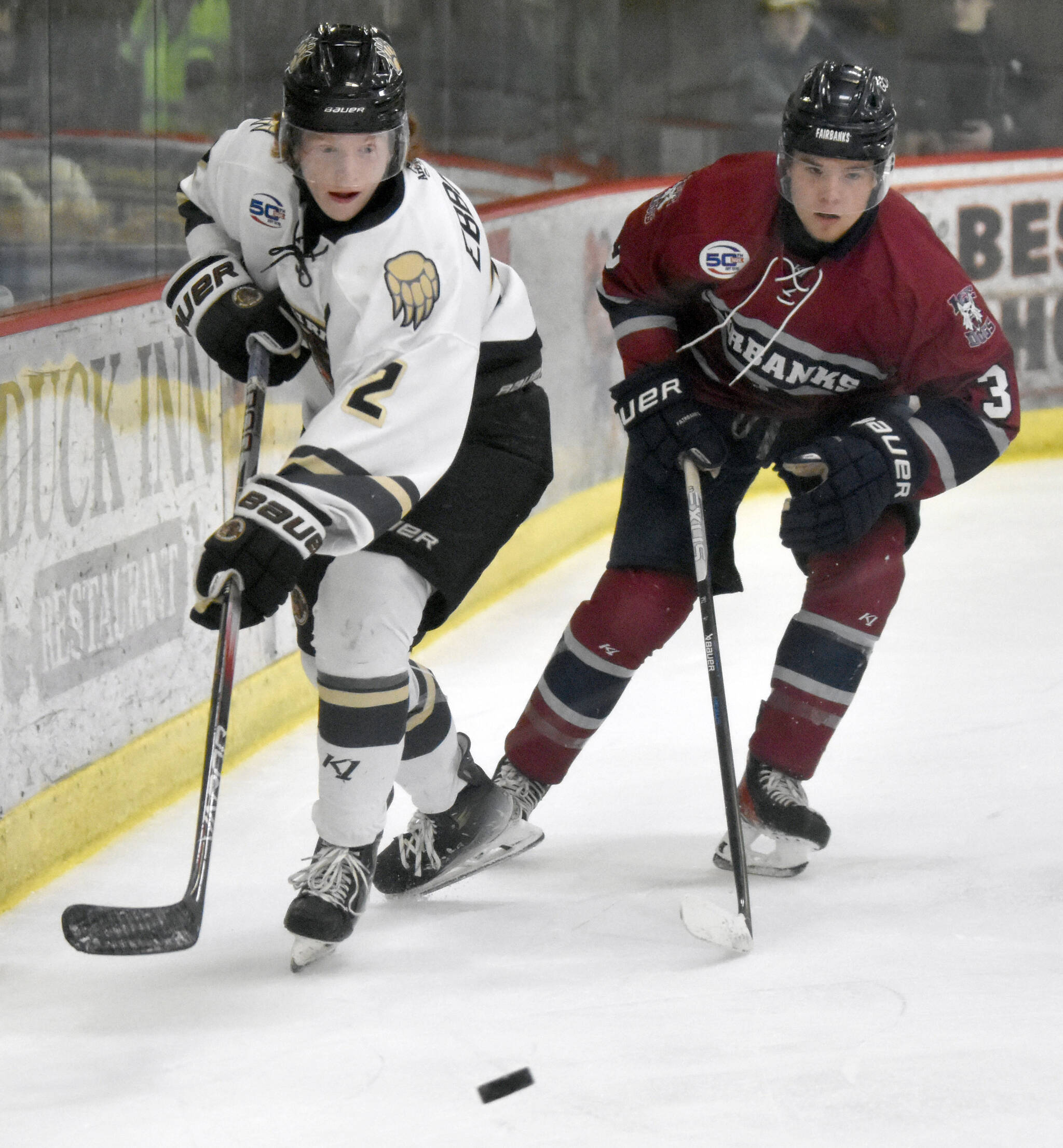 Jackson Ebbott of the Kenai River Brown Bears passes the puck in front of Nick Madsen of the Fairbanks Ice Dogs on Friday, Oct. 25, 2024, at the Soldotna Regional Sports Complex in Soldotna, Alaska. (Photo by Jeff Helminiak/Peninsula Clarion)