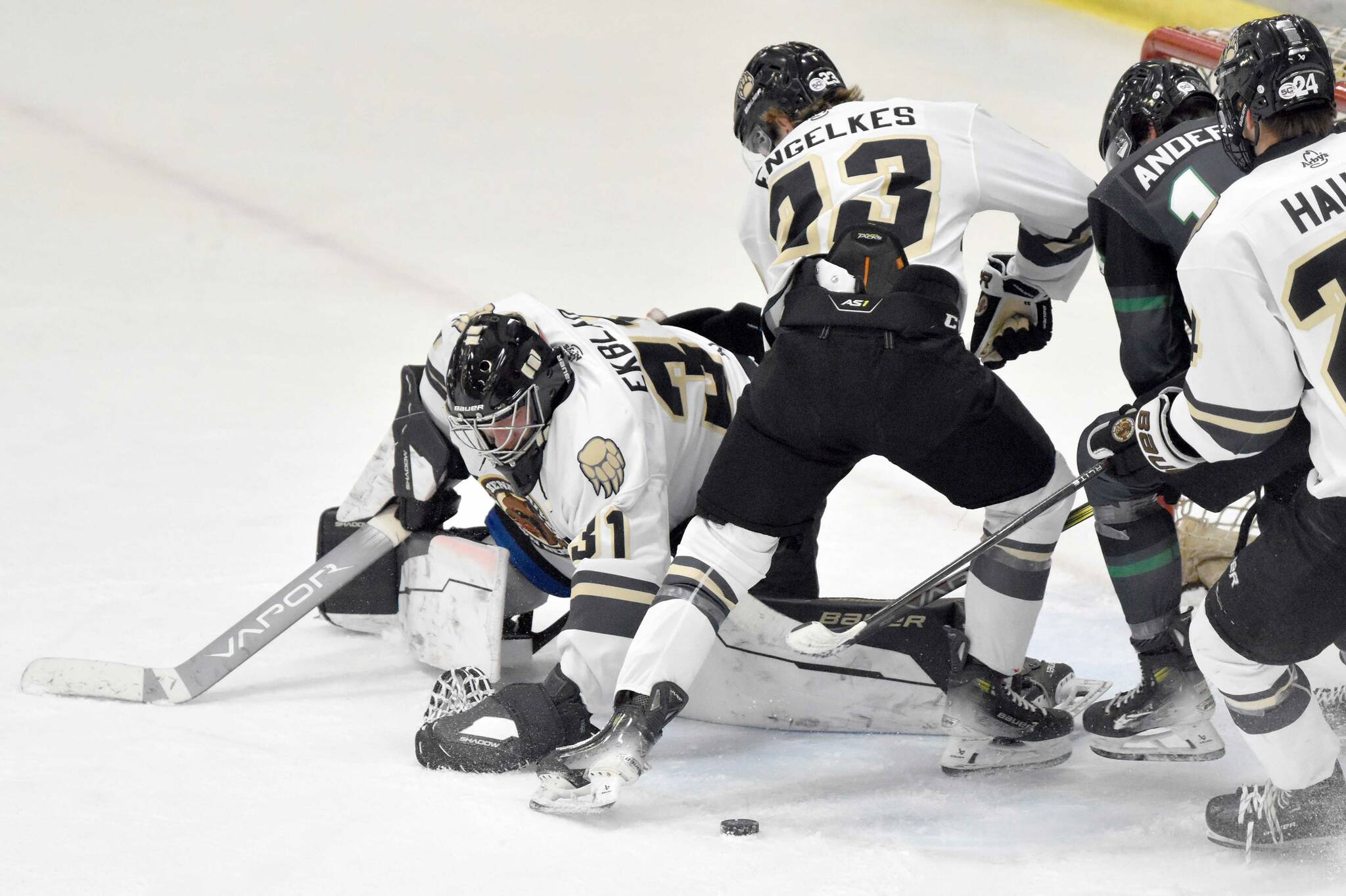 Kenai River Brown Bears goalie Leif Ekblad moves to cover the puck while teammates Brady Engelkes and Luke Hause try to keep Avery Anderson of the Minnesota Wilderness from scoring Saturday, Nov. 2, 2024, at the Soldotna Regional Sports Complex in Soldotna, Alaska. (Photo by Jeff Helminiak/Peninsula Clarion)