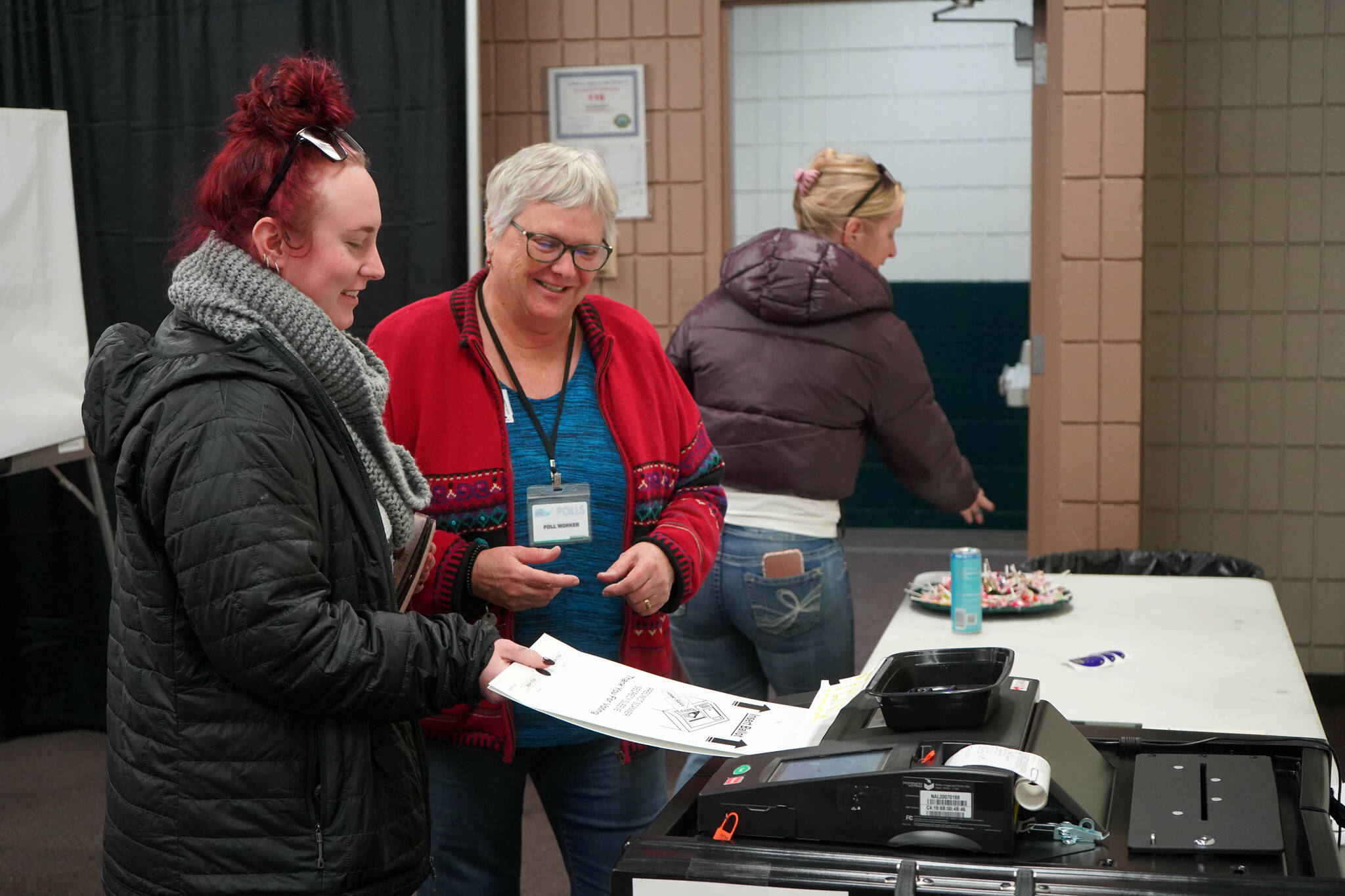 Poll worker Carol Louthan helps voters submit ballots at the Soldotna Regional Sports Complex in Soldotna, Alaska, on Tuesday, Nov. 5, 2024. (Jake Dye/Peninsula Clarion)