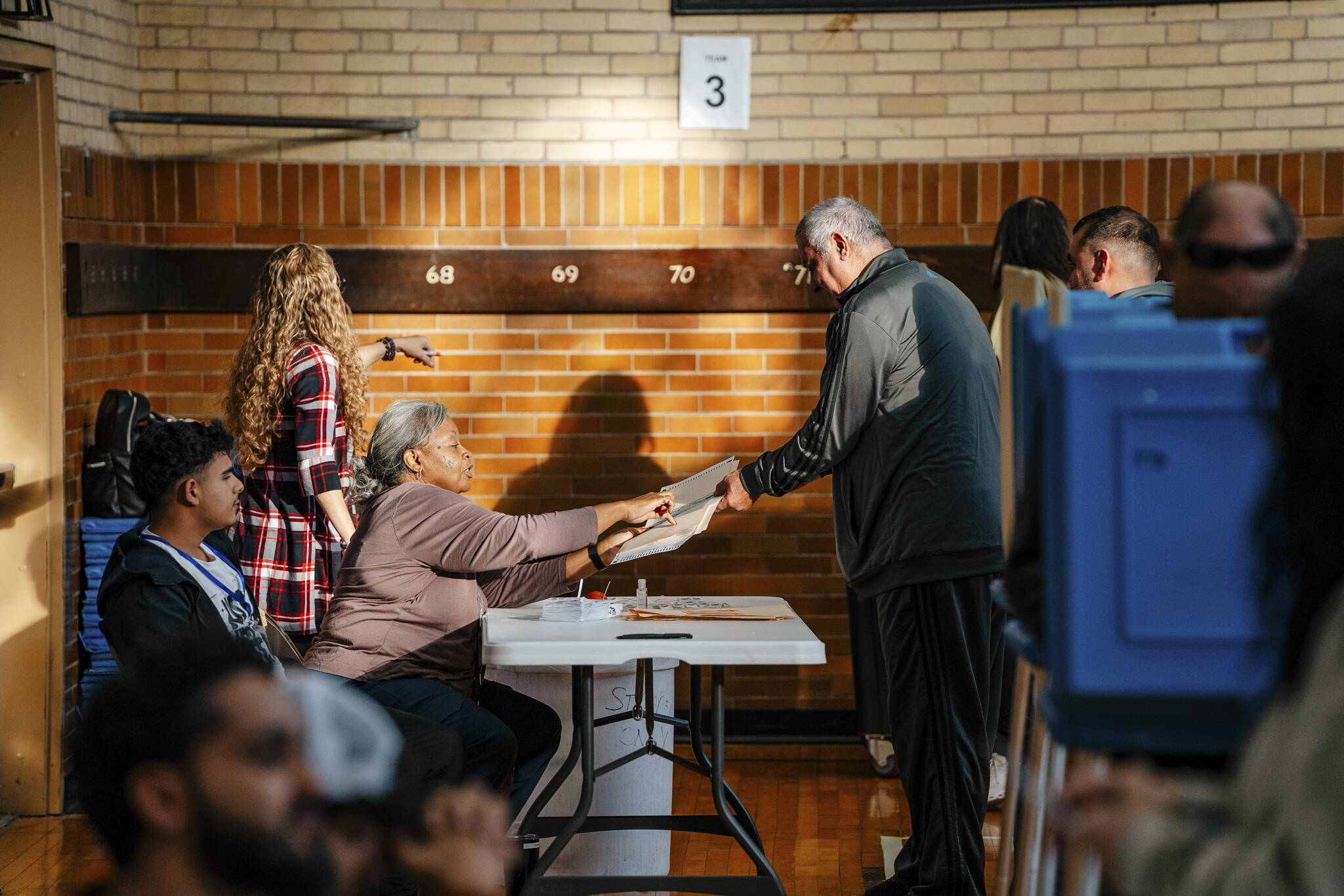 A voter is handed as ballot at Woodworth School in Dearborn, Mich., on Tuesday, Nov. 5, 2024. One of the most consequential presidential elections in the nation’s modern history is well underway, as voters flocked to churches, schools and community centers to shape the future of American democracy. (Nick Hagen/The New York Times)