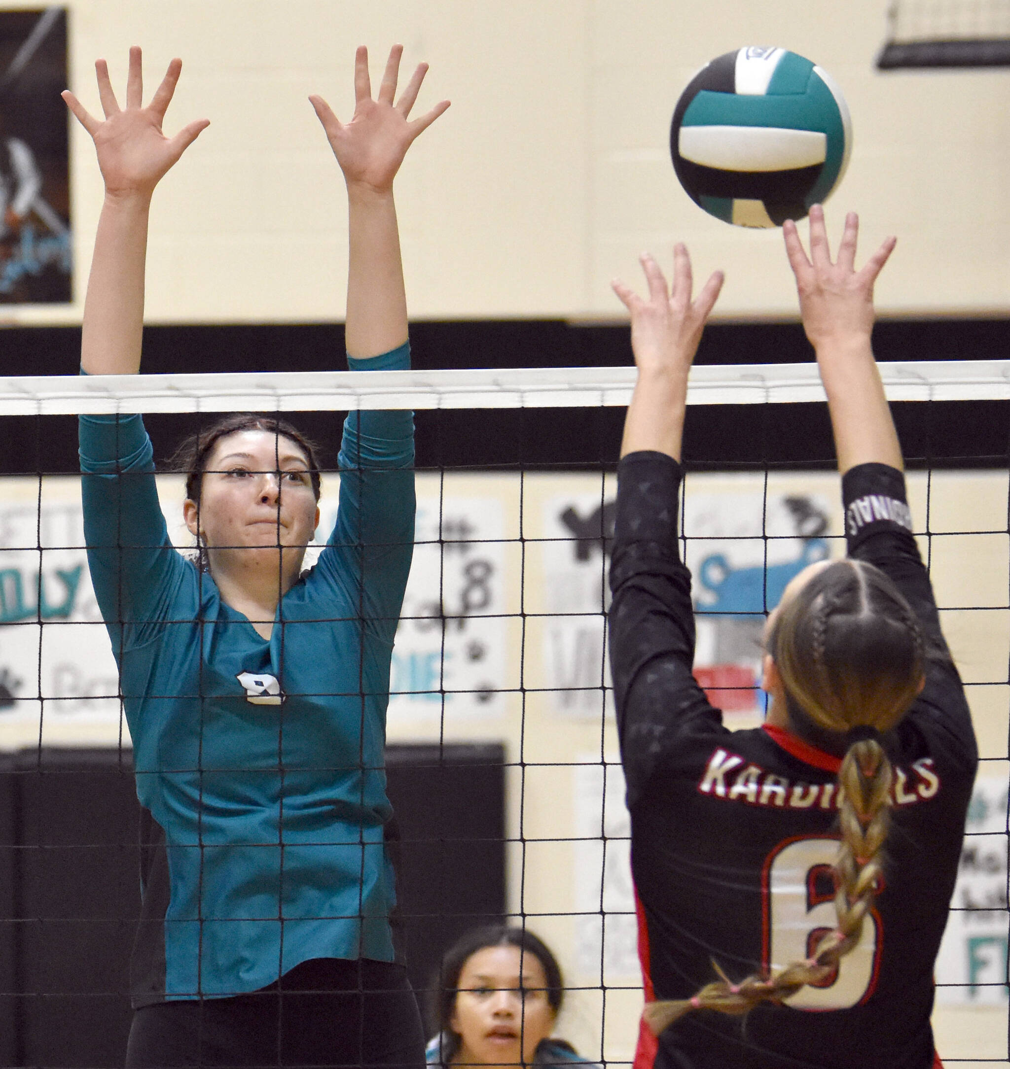 Nikiski’s Ashlynne Playle puts up a block on Kenai Central’s Stella Selanoff at the Southcentral Conference volleyball tournament at Nikiski Middle-High School in Nikiski, Alaska, on Saturday, Nov. 9, 2024. (Photo by Jeff Helminiak/Peninsula Clarion)