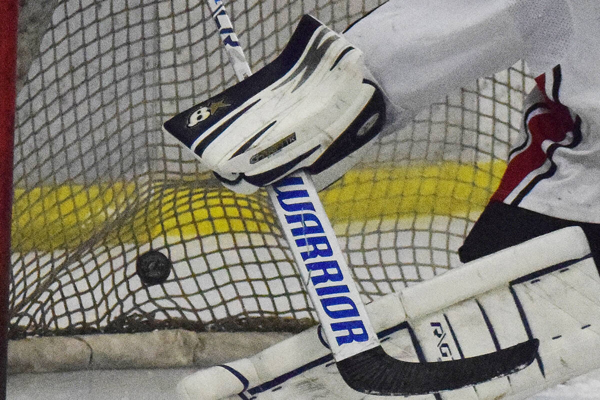 Kenai Central goaltender Carson Koppes attempts to block a shot by a North Pole skater Thursday night at the Peninsula Ice Challenge at the Kenai Multi-purpose Facility. (Photo by Joey Klecka/Peninsula Clarion)