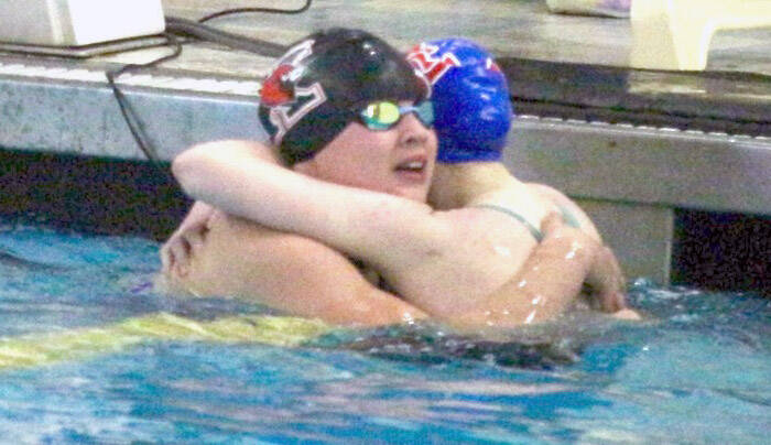 Kenai’s Abigail Price hugs Taryn Fleming from Sitka during the state swimming and diving championships Saturday, Nov. 9, 2024, at Bartlett High School in Anchorage, Alaska. (Photo by Kyle Wilkinson/For the Frontiersman)