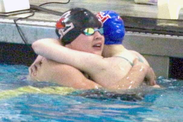 Kenai’s Abigail Price hugs Taryn Fleming from Sitka during the state swimming and diving championships Saturday, Nov. 9, 2024, at Bartlett High School in Anchorage, Alaska. (Photo by Kyle Wilkinson/For the Frontiersman)