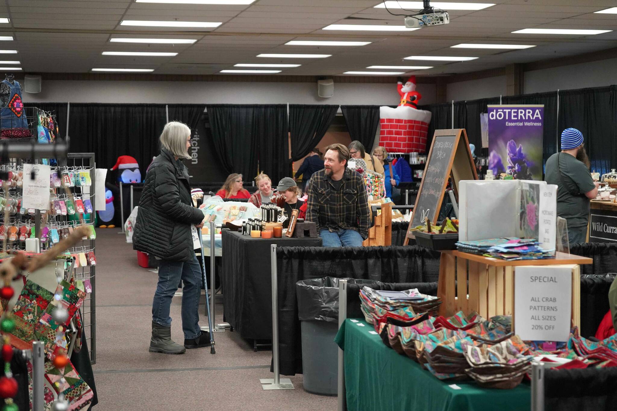 Henry Dera, of Crooked Creek Birch, chats with shoppers at the 33rd Annual Holiday Bazaar at the Soldotna Regional Sports Complex in Soldotna, Alaska, on Friday, Nov. 22, 2024. (Jonas Oyoumick/Peninsula Clarion)