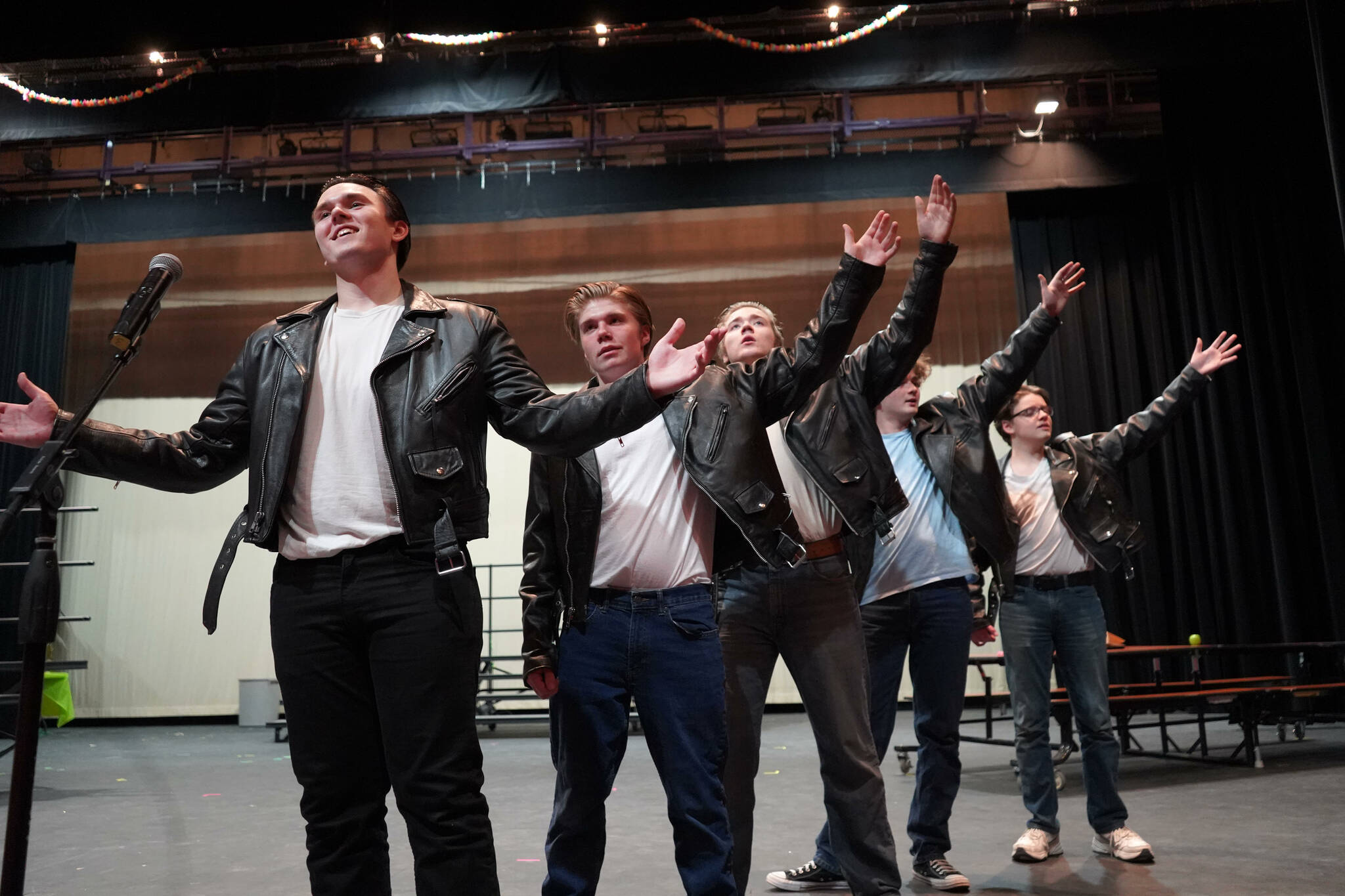 The cast of Soldotna High School’s “Grease” rehearse in the Soldotna High School auditorium in Soldotna, Alaska, on Monday, Nov. 25, 2024. (Jake Dye/Peninsula Clarion)