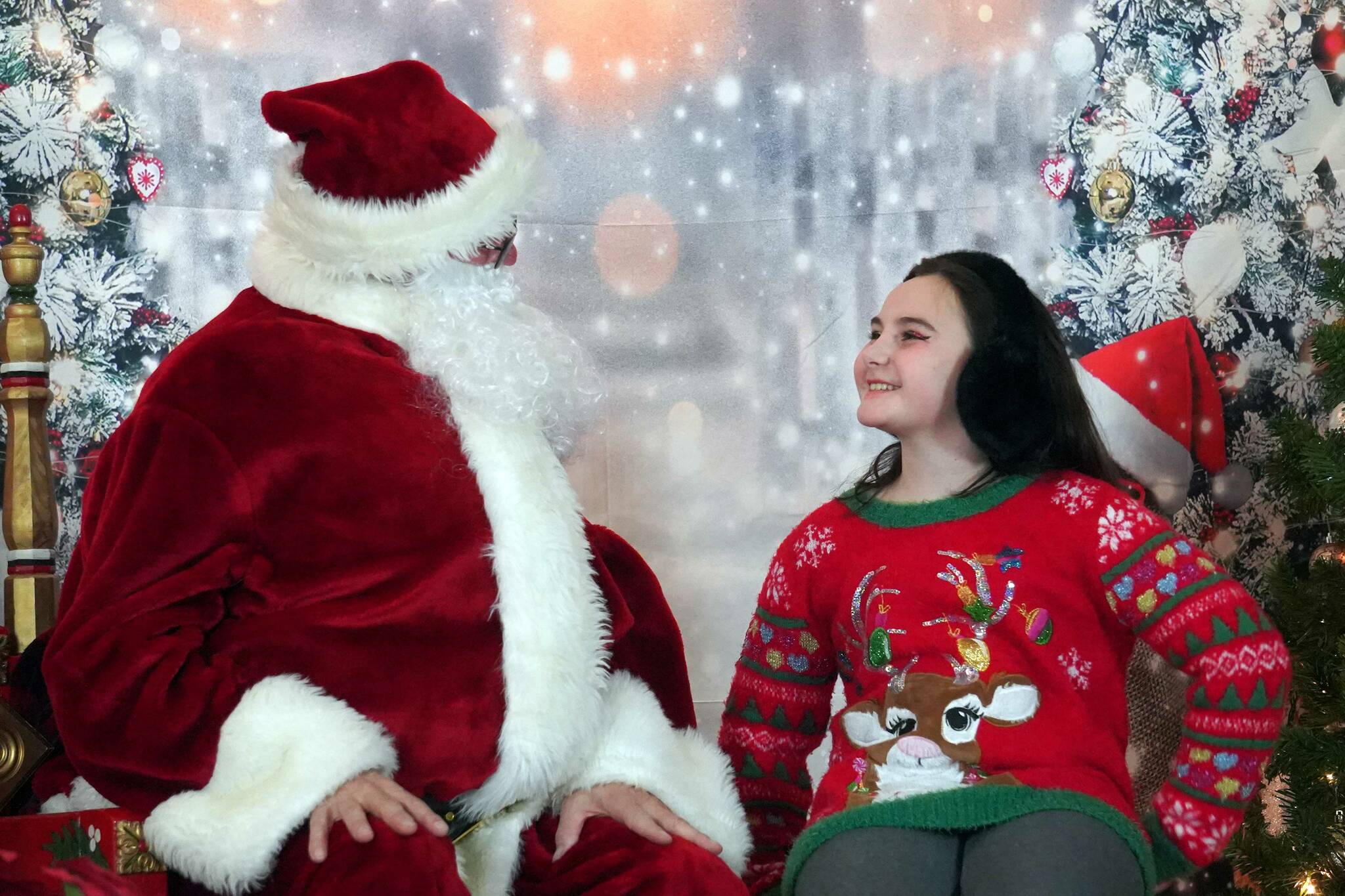 Santa Claus greets Gemma Germann during Christmas Comes to Kenai at the Kenai Chamber of Commerce and Visitor Center in Kenai, Alaska, on Friday, Nov. 29, 2024. (Jake Dye/Peninsula Clarion)