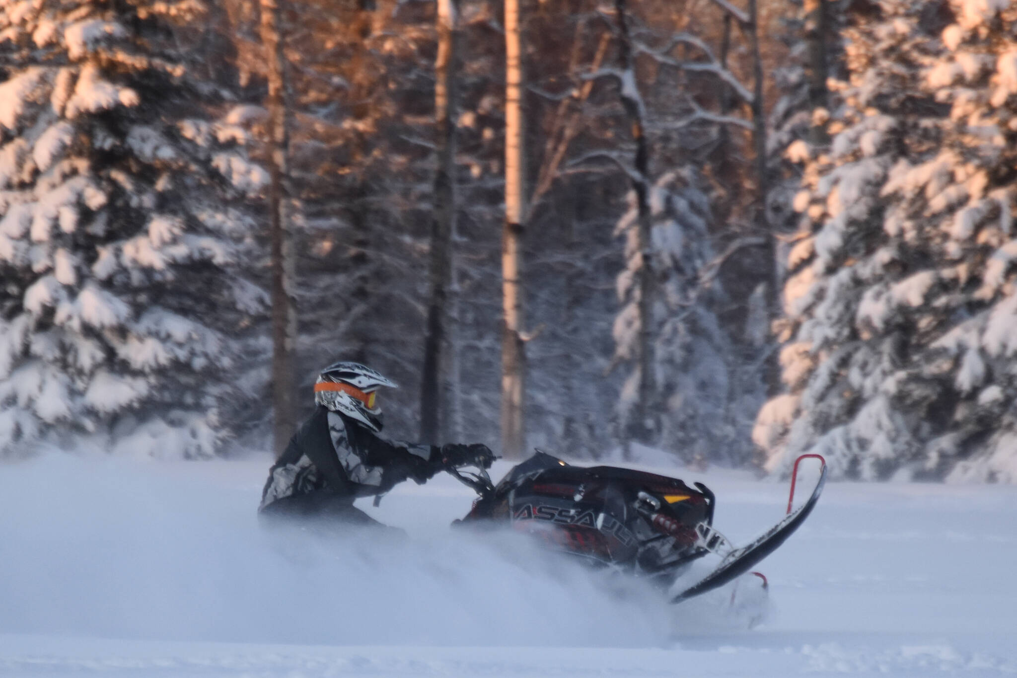 A snowmachine rider takes advantage of 2 feet of fresh snow on a field down Murwood Avenue in Soldotna, Alaska, on Monday, Dec. 12, 2022. (Jake Dye/Peninsula Clarion)