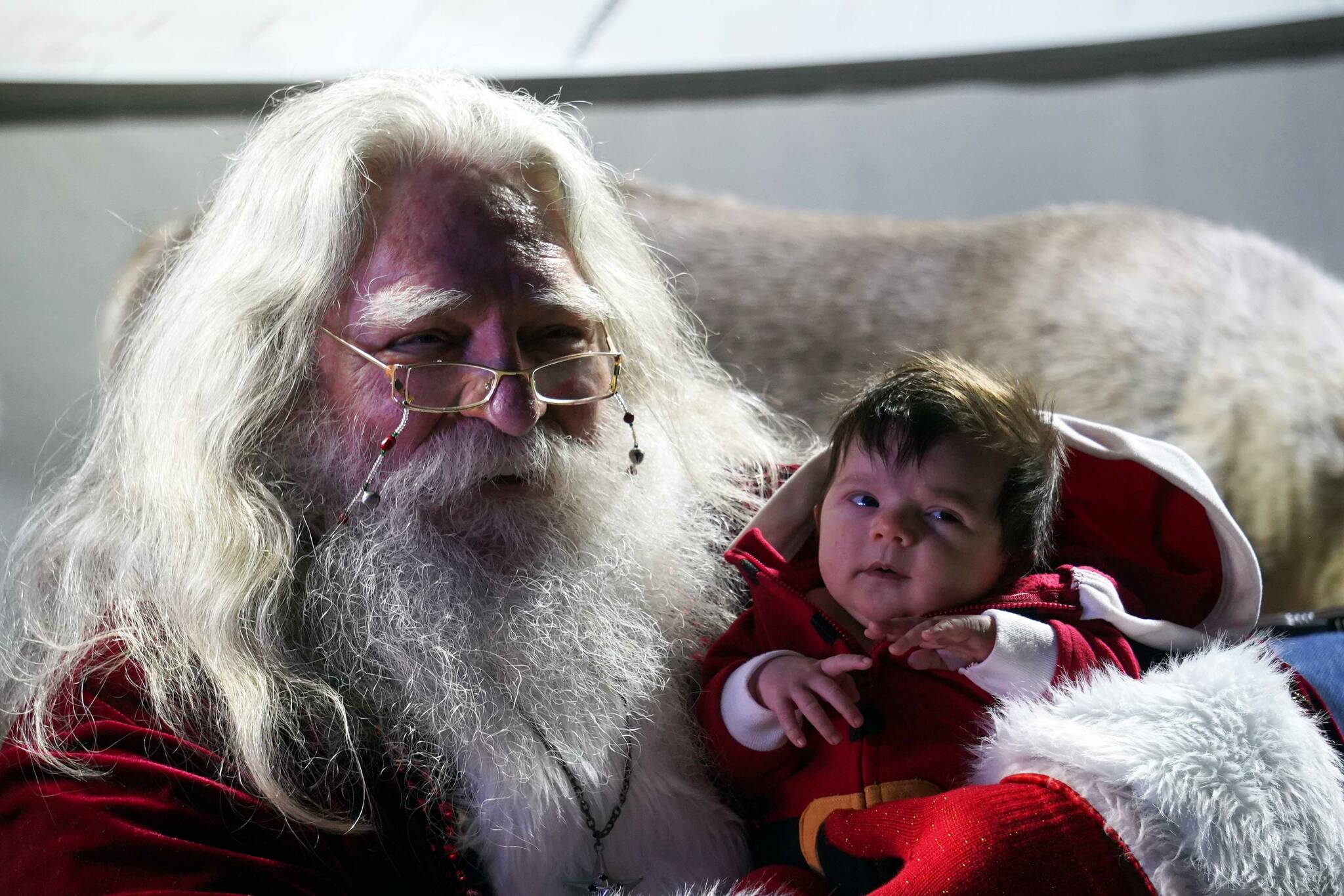 Harley St. Clair, 5 weeks old, meets Santa Claus for the first time at Christmas in the Park at Soldotna Creek Park in Soldotna, Alaska, on Saturday, Dec. 7, 2024. (Jake Dye/Peninsula Clarion)