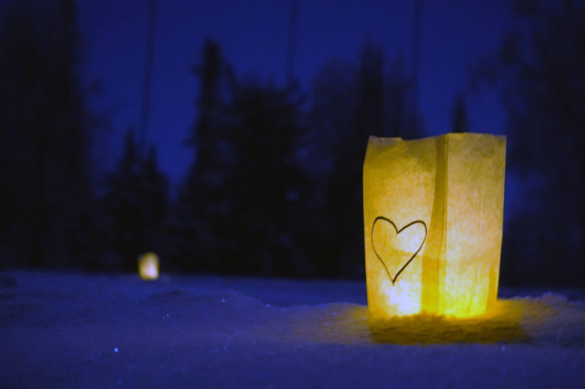 Luminaria light the path of the Third Annual StarLight StarBright winter solstice skiing fundraiser at the Kenai Golf Course in Kenai, Alaska, on Thursday, Dec. 21, 2023. (Jake Dye/Peninsula Clarion)