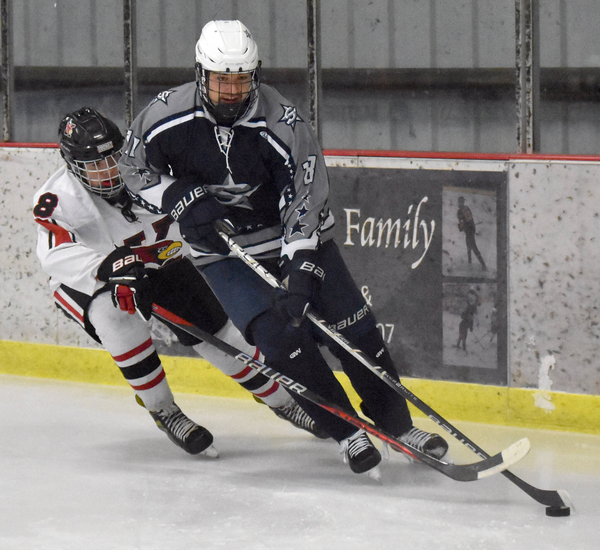 Soldotna's Nathan Hawkins protects the puck from Kenai Central's Everett Chamberlain on Tuesday, Dec. 17, 2024, at the Kenai Multi-Purpose Facility in Kenai, Alaska. (Photo by Jeff Helminiak/Peninsula Clarion)