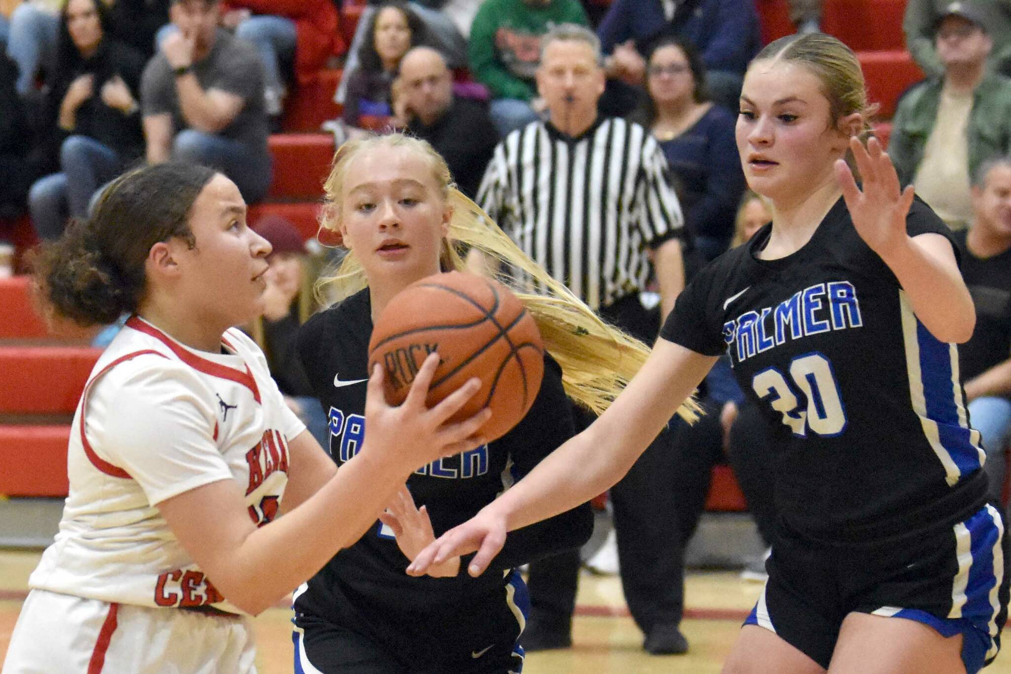 Kenai Central's Bryleigh Williams drives against Palmer's Kaylyn Miller and Jasmine Hephner on Thursday, Dec. 19, 2024, at Kenai Central High School in Kenai, Alaska. (Photo by Jeff Helminiak/Peninsula Clarion)