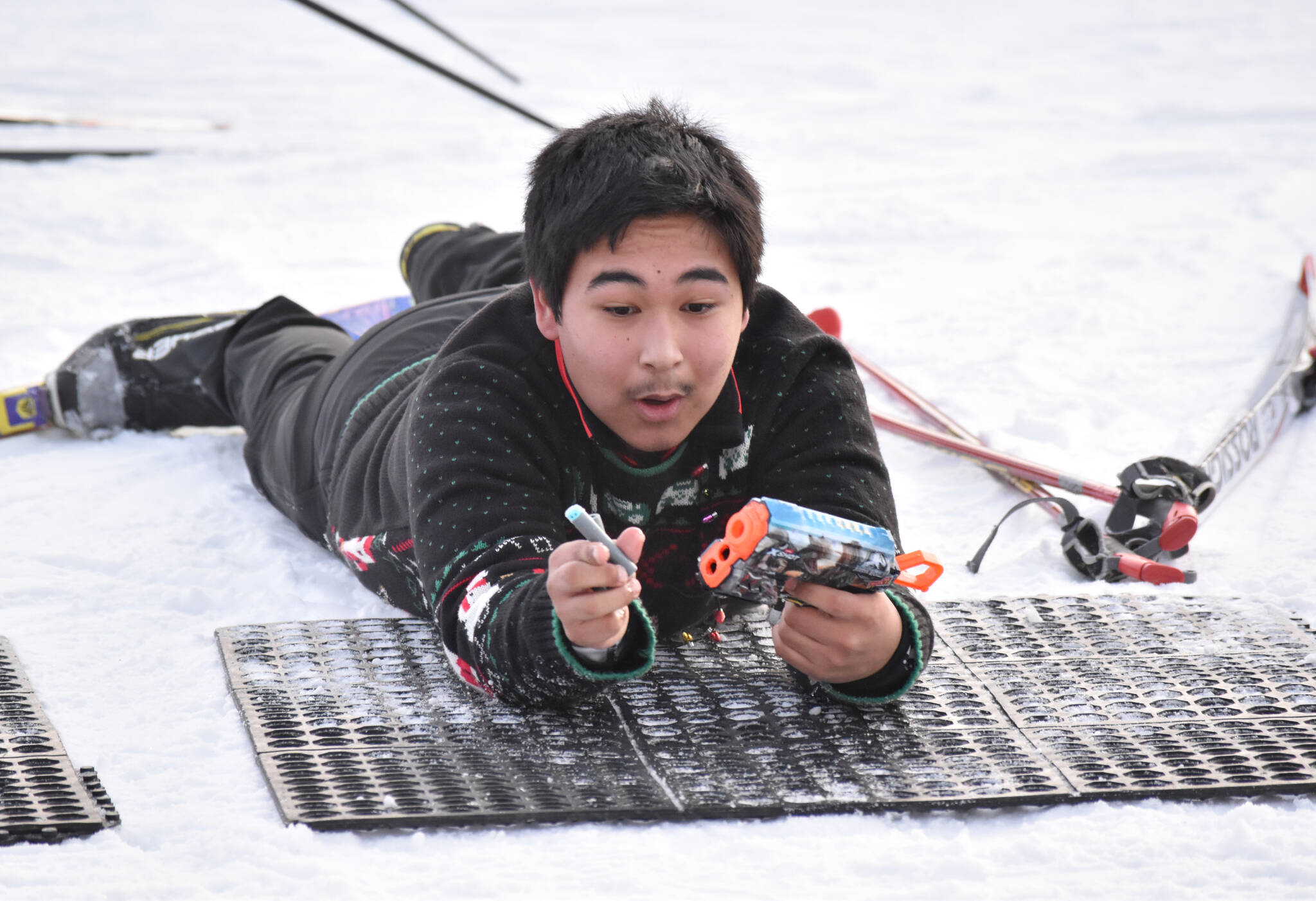 Kenai Central's Kaden Bee loads a bullet at the Candy Cane Scramble on Friday, Dec. 20, 2024, at Tsalteshi Trails just outside of Soldotna, Alaska. (Photo by Jeff Helminiak/Peninsula Clarion)