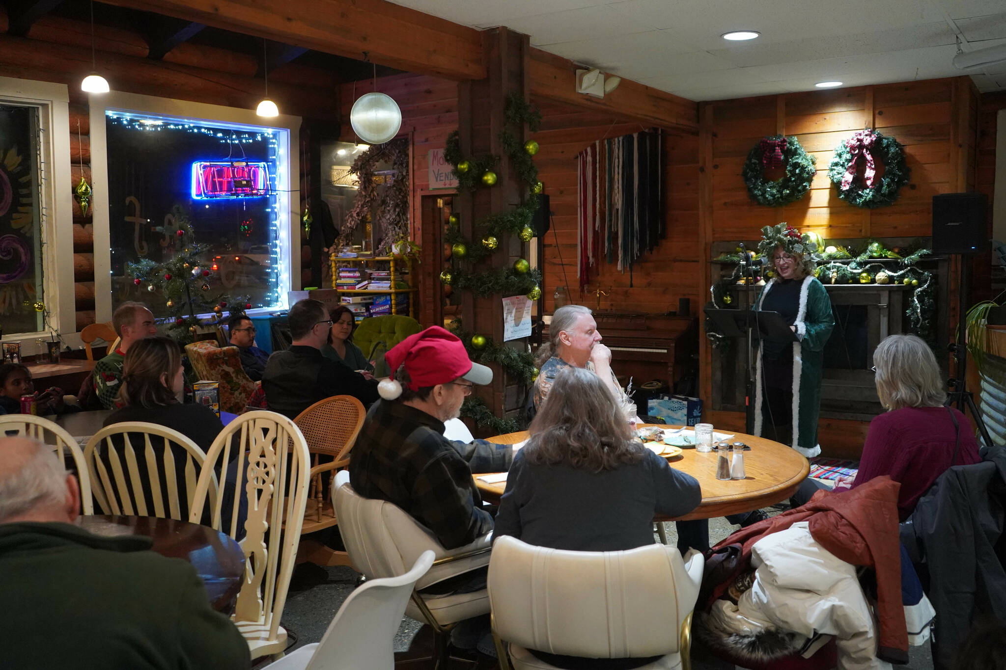 AnnMarie Rudstrom, dressed as the Ghost of Christmas Present, reads Charles Dickens’ “A Christmas Carol” at The Goods in Soldotna, Alaska, on Thursday, Dec. 19, 2024. (Jake Dye/Peninsula Clarion)