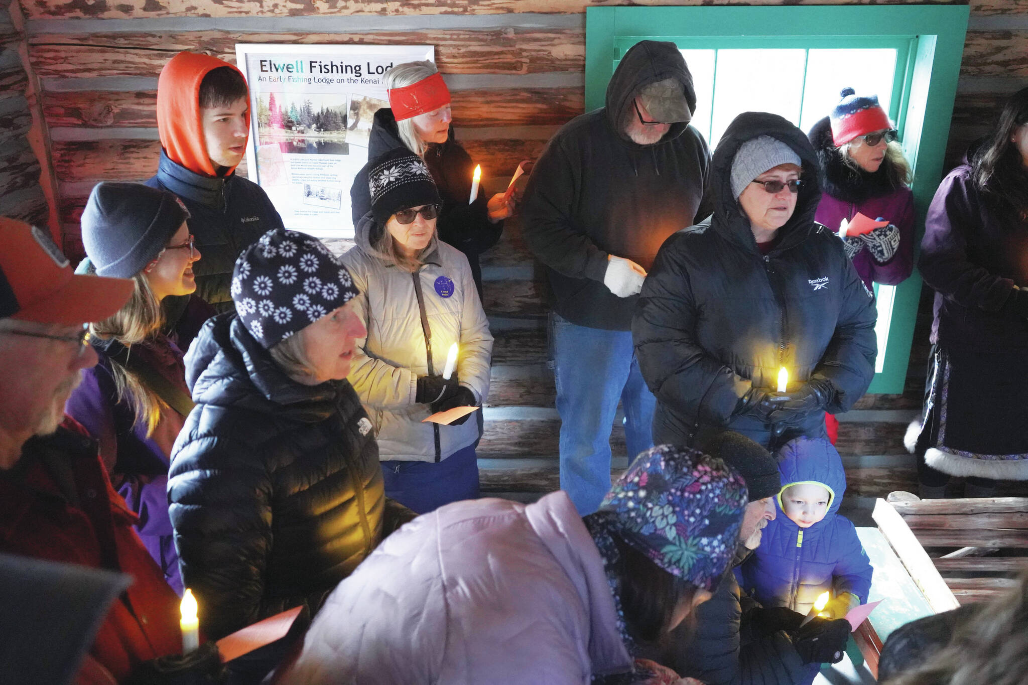 Jake Dye/Peninsula Clarion
A group of people sing “Silent Night” in the Elwell Fishing Lodge at the Kenai National Wildlife Refuge near Soldotna on Christmas Eve.