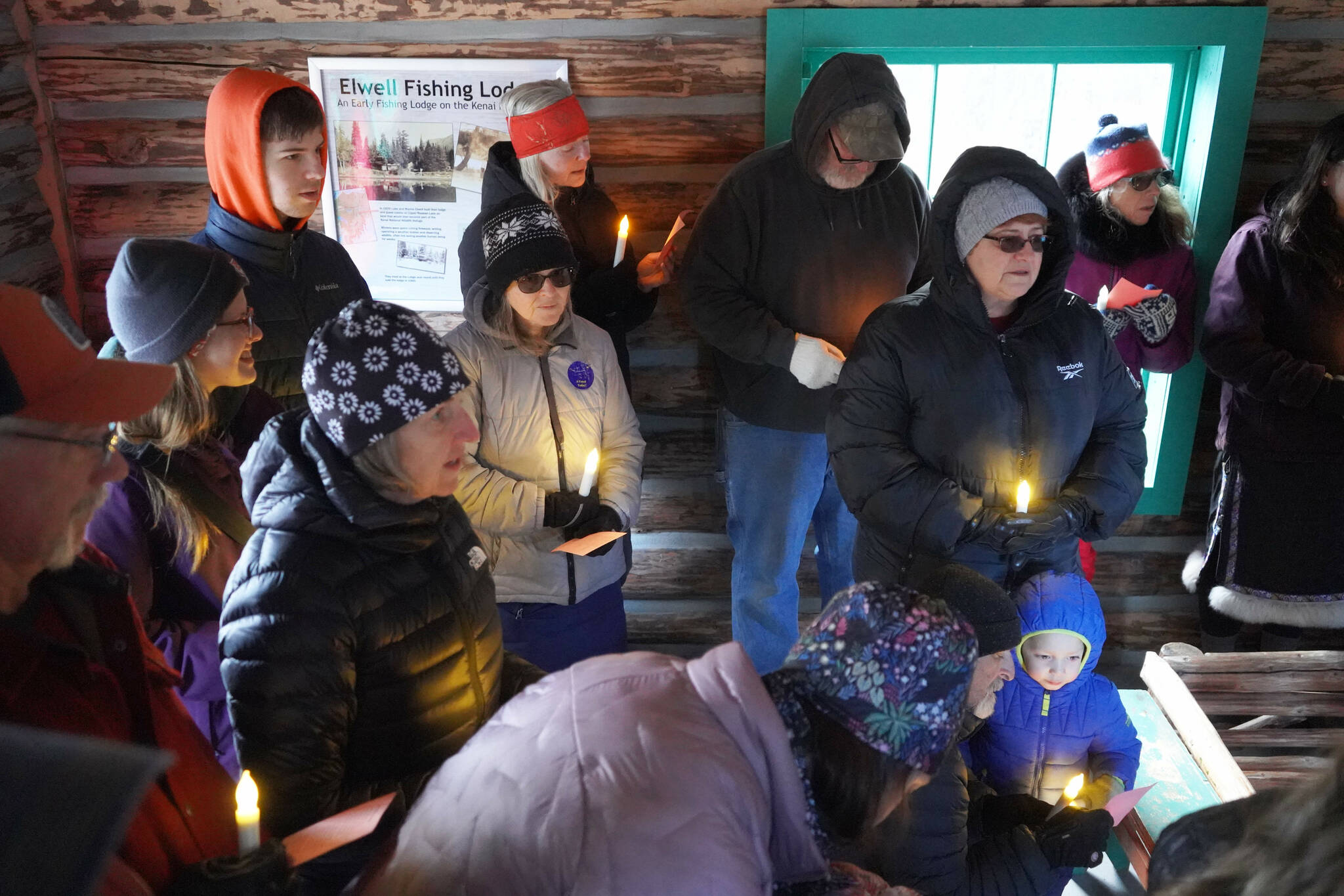 A group of people sing “Silent Night” in the Elwell Fishing Lodge at the Kenai National Wildlife Refuge near Soldotna, Alaska, on Christmas Eve, Dec. 24, 2024. (Jake Dye/Peninsula Clarion)