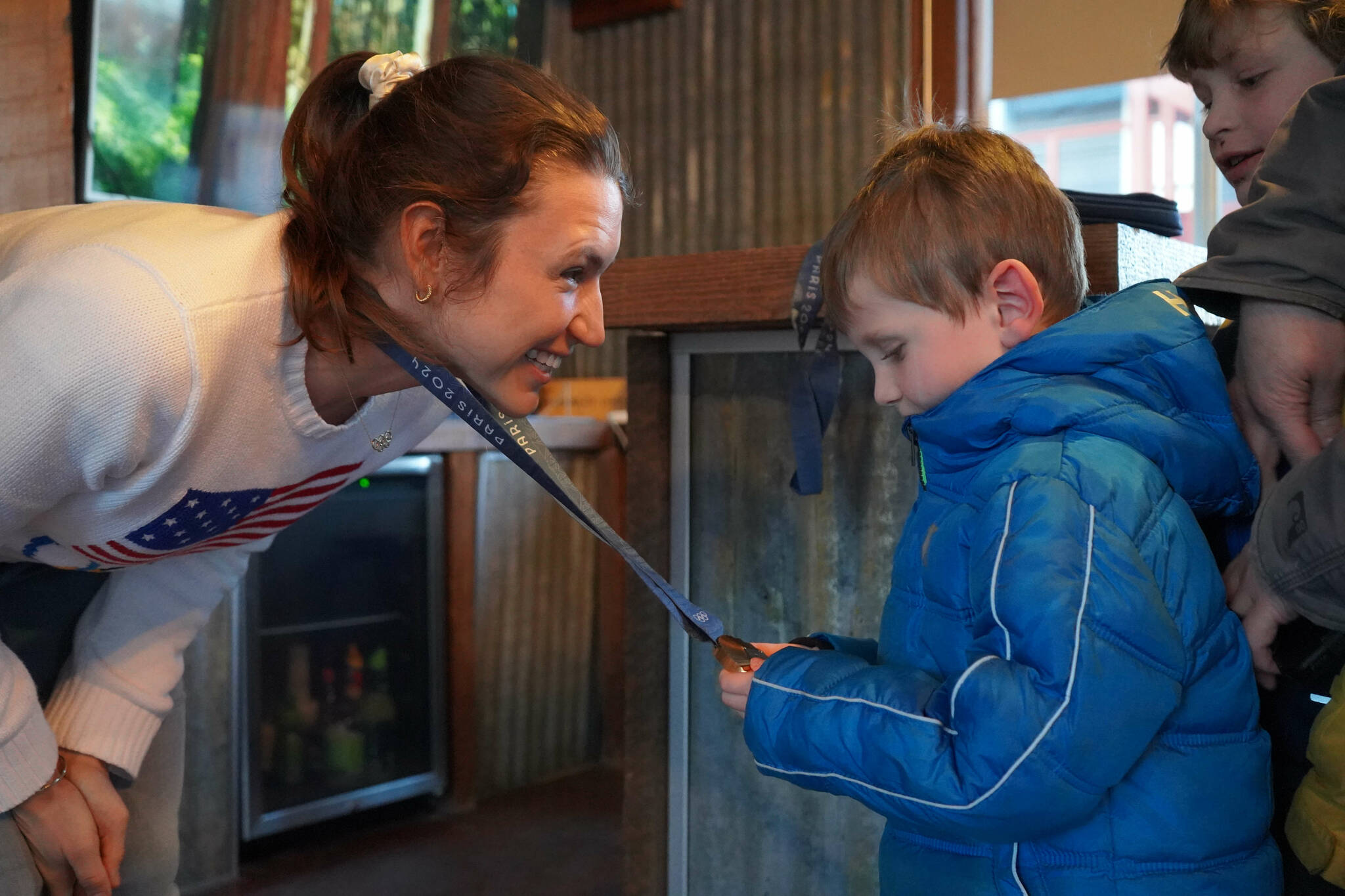 Kristen Faulkner, who won two gold medals for cycling at the Paris 2024 Olympics, speaks to Andrew Elam during a meet and greet hosted by the Kenai and Soldotna chambers of commerce at the Cannery Lodge in Kenai, Alaska, on Saturday, Dec. 28, 2024. (Jake Dye/Peninsula Clarion)