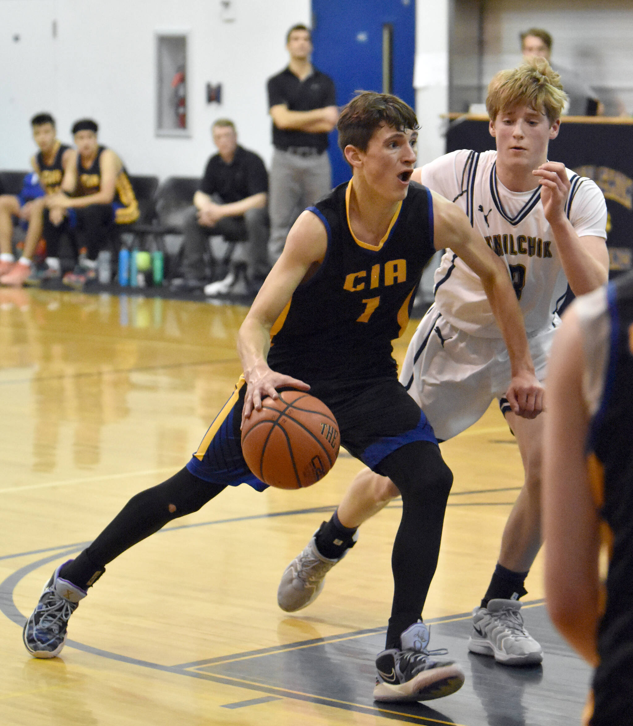 Cook Inlet Academy’s Alek McGarry drives on Ninilchik’s Andon McCorison on Tuesday, Jan. 8, 2025, at Ninilchik School in Ninilchik, Alaska. (Photo by Jeff Helminiak/Peninsula Clarion)