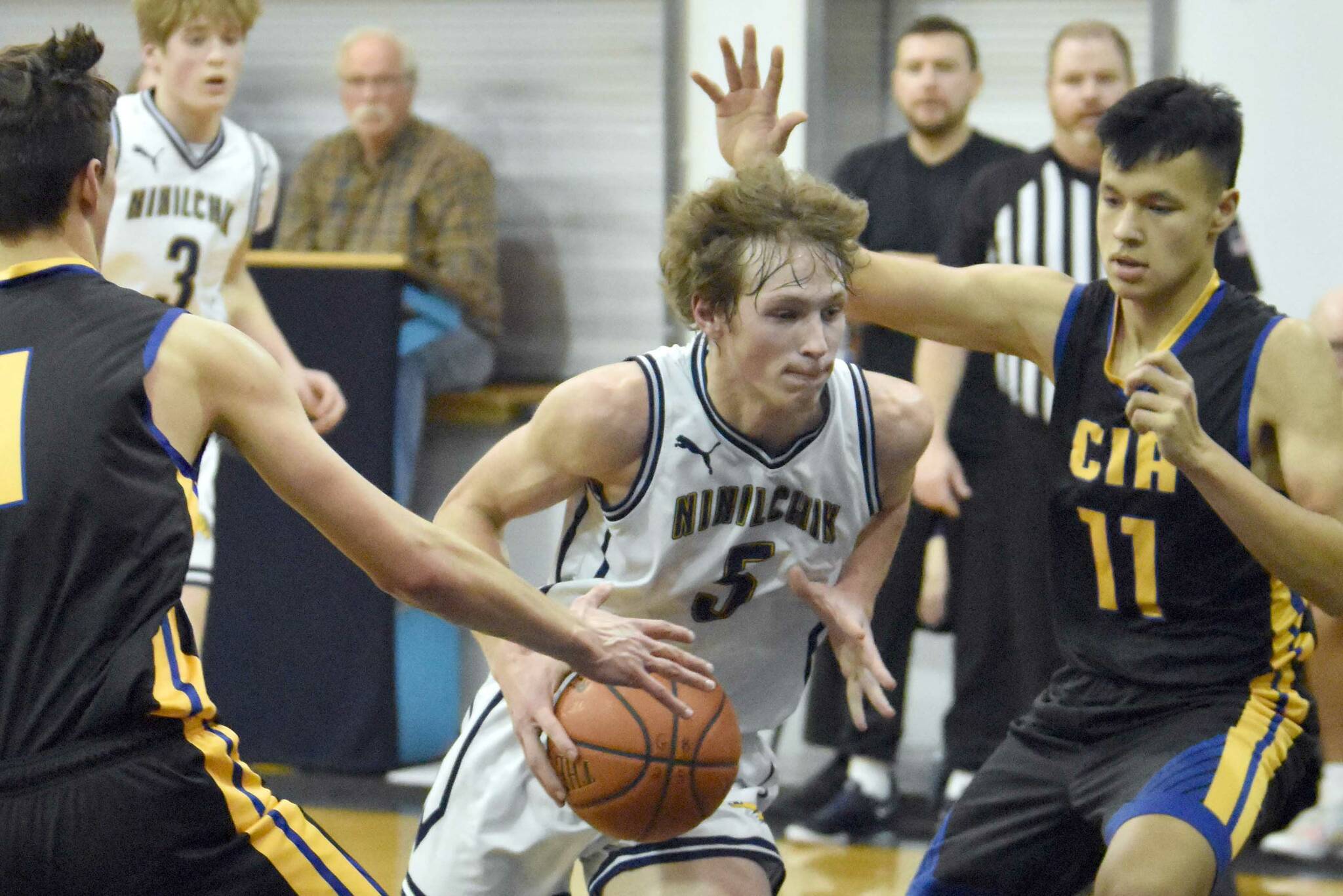 Ninilchik's Kade McCorison drives on Cook Inlet Academy's Lucas Oyoumick on Tuesday, Jan. 7, 2025, at Ninilchik School in Ninilchik, Alaska. (Photo by Jeff Helminiak/Peninsula Clarion)