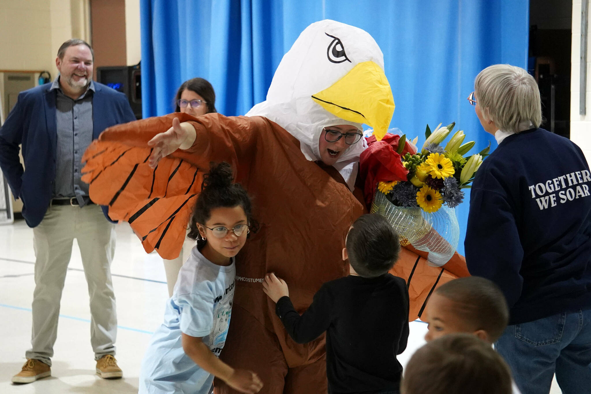 Students embrace Aubrie Ellis after she was named National Outstanding Assistant Principal of 2025 by the Alaska Association of Elementary School Principals at Mountain View Elementary School in Kenai, Alaska, on Friday, Jan. 10, 2025. (Jake Dye/Peninsula Clarion)