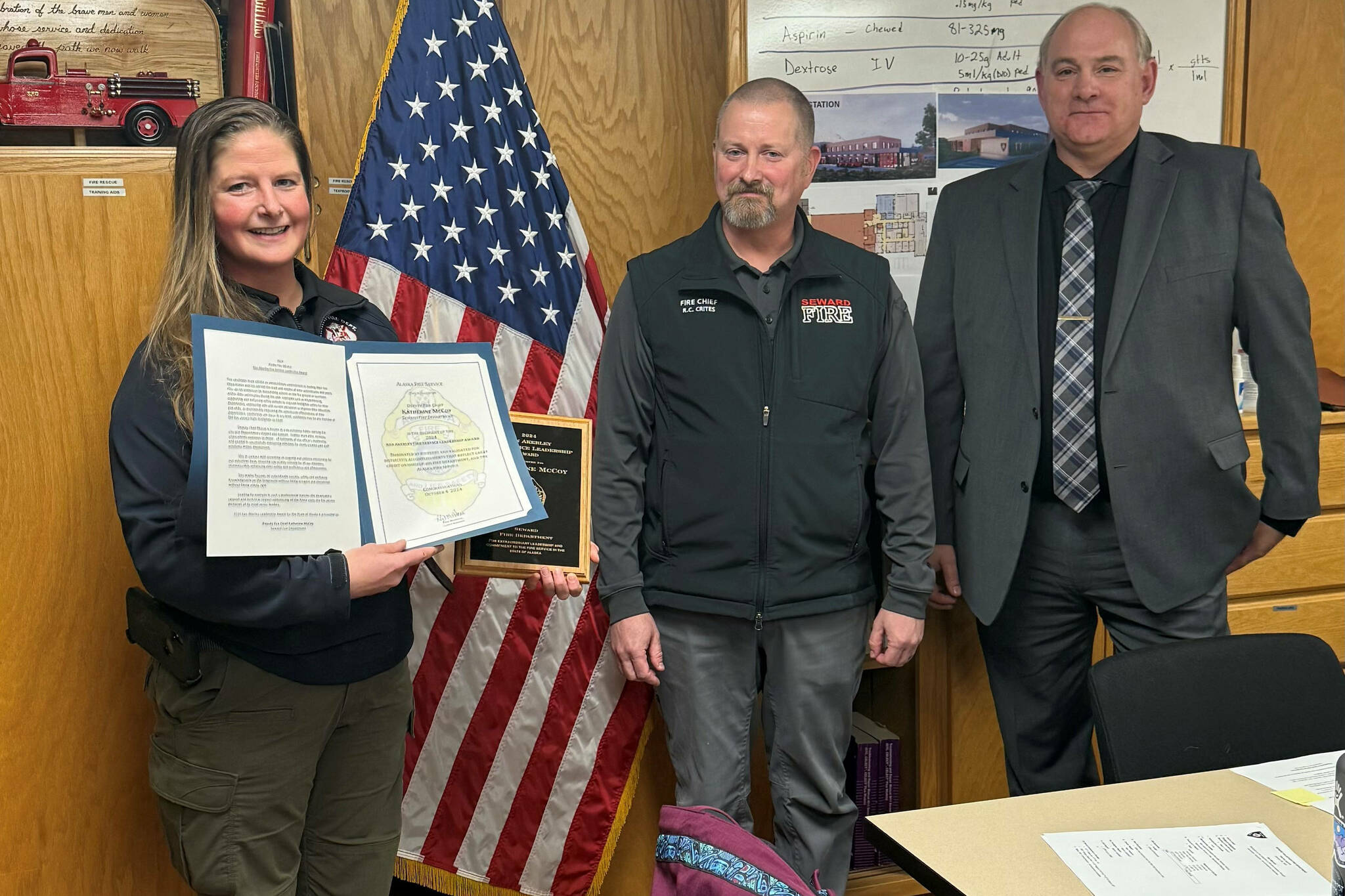 Seward Deputy Fire Chief Katherine McCoy stands for a photo with Seward Fire Chief Clinton Crites and Assistant State Fire Marshal Mark Brauneis after McCoy was presented the 2024 Ken Akerley Fire Service Leadership Award at Seward Fire Department in Seward, Alaska. (Photo provided by Seward Fire Chief Clinton Crites)