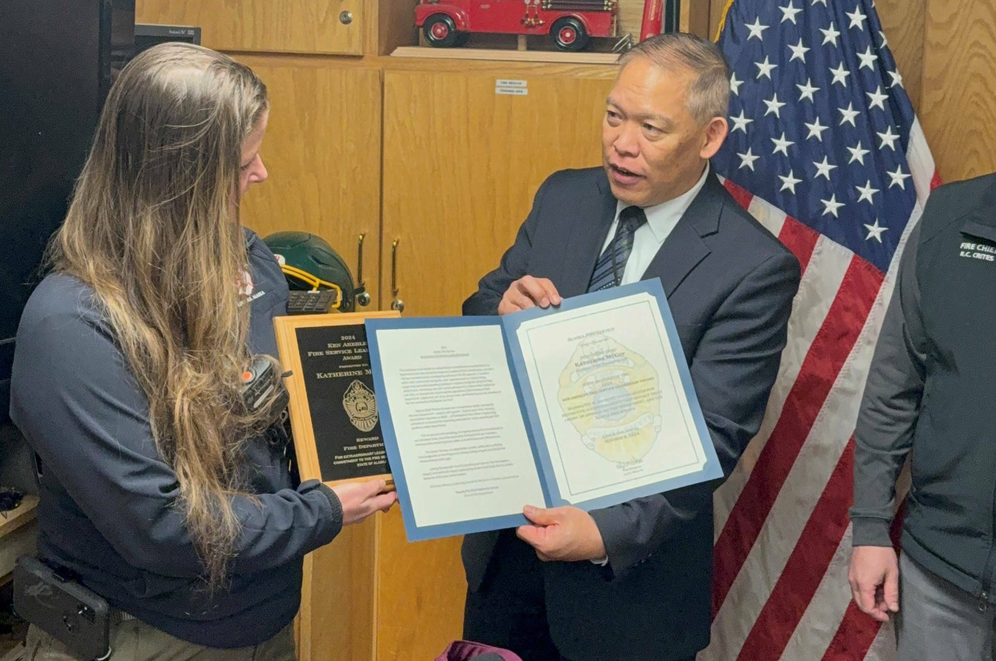 Seward Deputy Fire Chief Katherine McCoy is presented the 2024 Ken Akerley Fire Service Leadership Award by State Fire Marshal Lloyd Nakano at Seward Fire Department in Seward, Alaska. (Photo provided by Seward Fire Chief Clinton Crites)