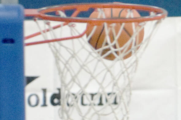 Nikolaevsk's Kristin Klaich shoots on Cook Inlet Academy's Emilee Cragg and Anna Cizek on Friday, Dec. 15, 2017, at Cook Inlet Academy. (Photo by Jeff Helminiak/Peninsula Clarion)