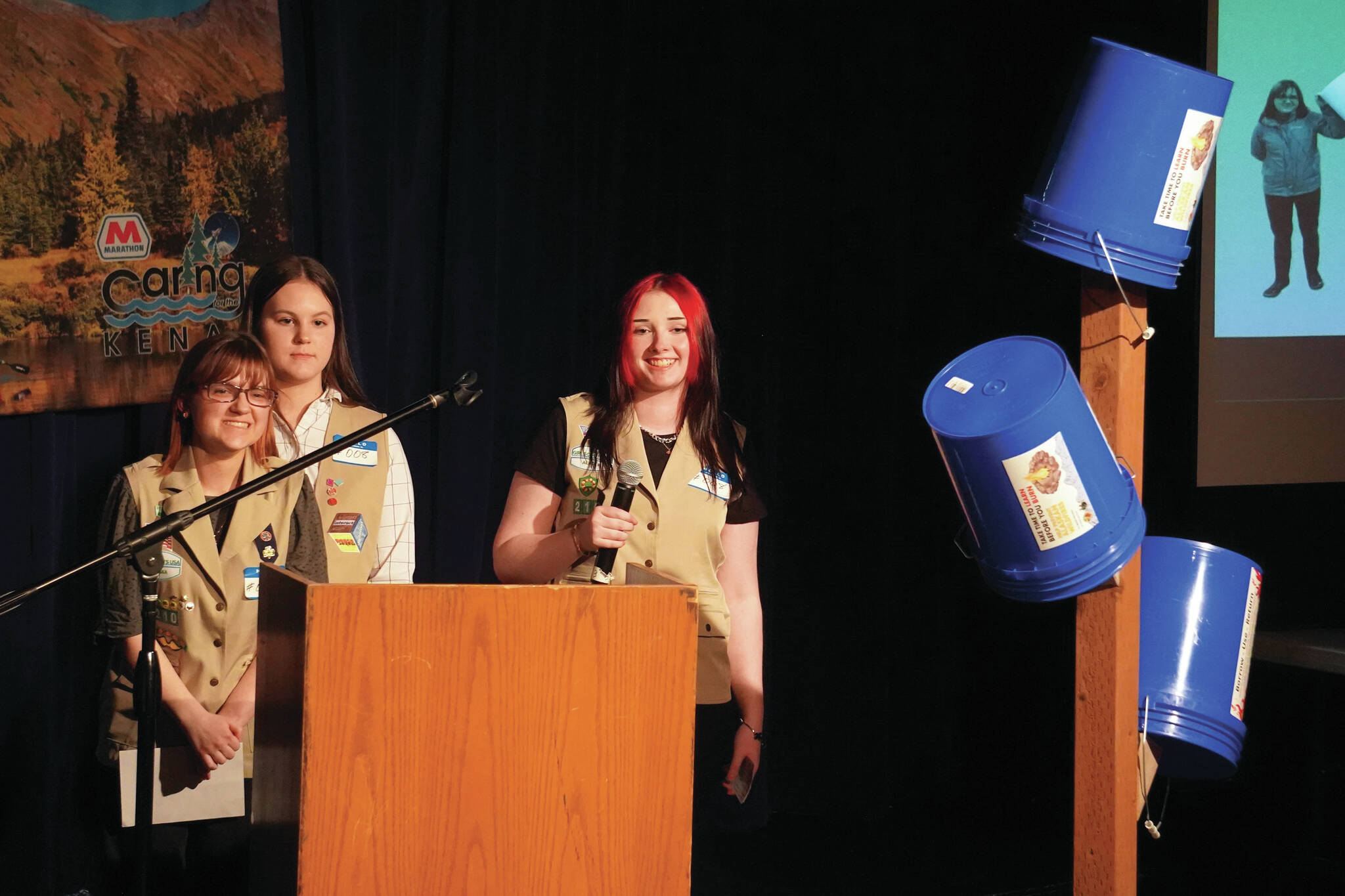 Girl Scout Troop 210, which includes Caitlyn Eskelin, Emma Hindman, Kadie Newkirk and Lyberty Stockman, present their “Bucket Trees” to a panel of judges in the 34th Annual Caring for the Kenai Competition at Kenai Central High School in Kenai, Alaska, on Thursday, April 18, 2024. (Jake Dye/Peninsula Clarion)